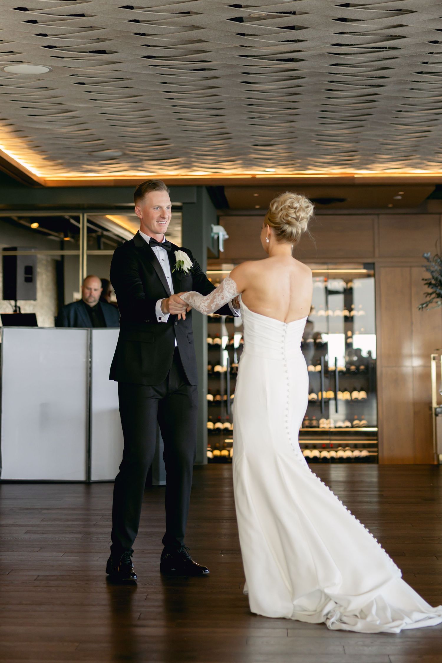 Bride and groom share their first dance in a modern upscale restaurant venue with warm ambient lighting.