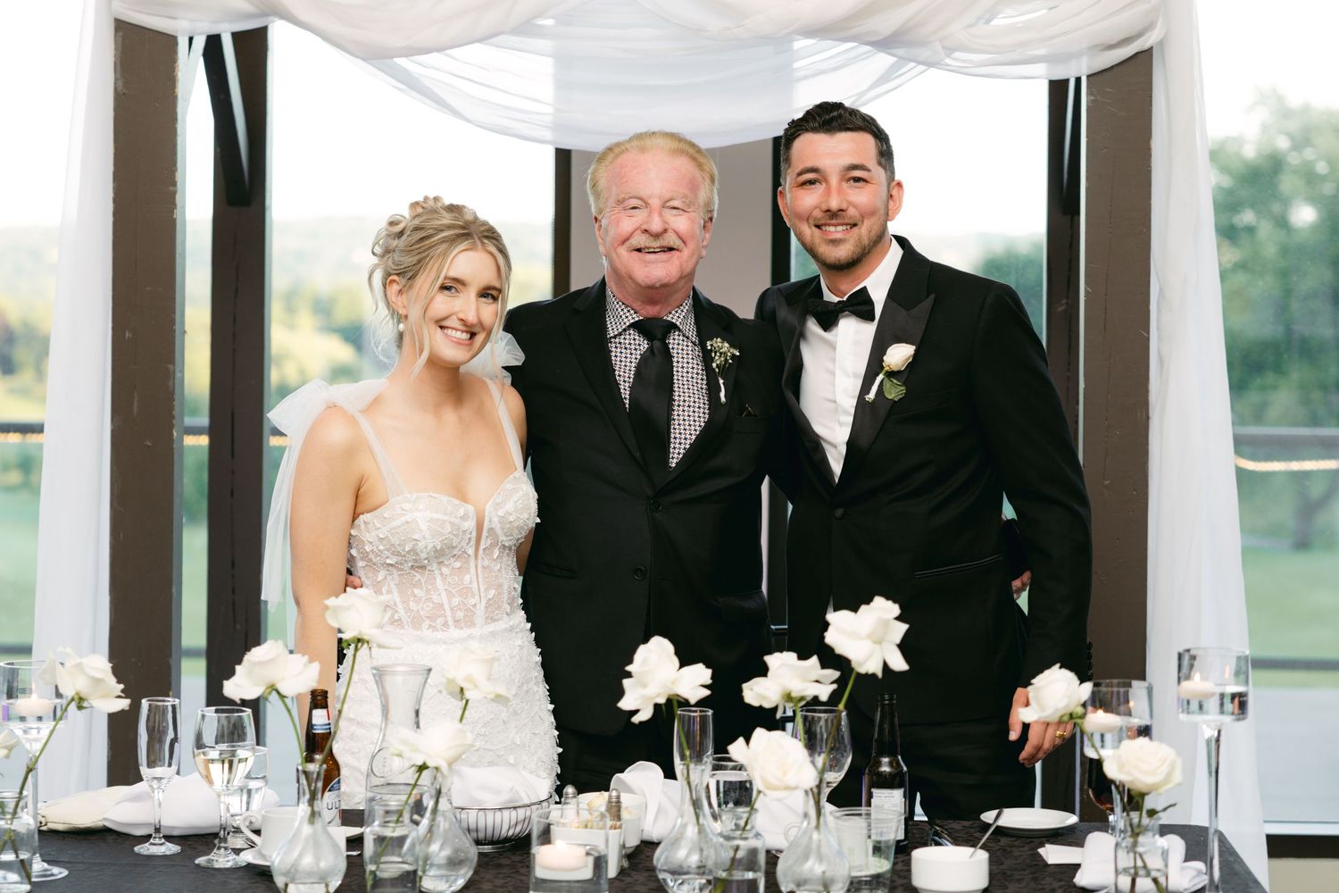 Elegant wedding reception tables decorated with white floral centerpieces and formal place settings.