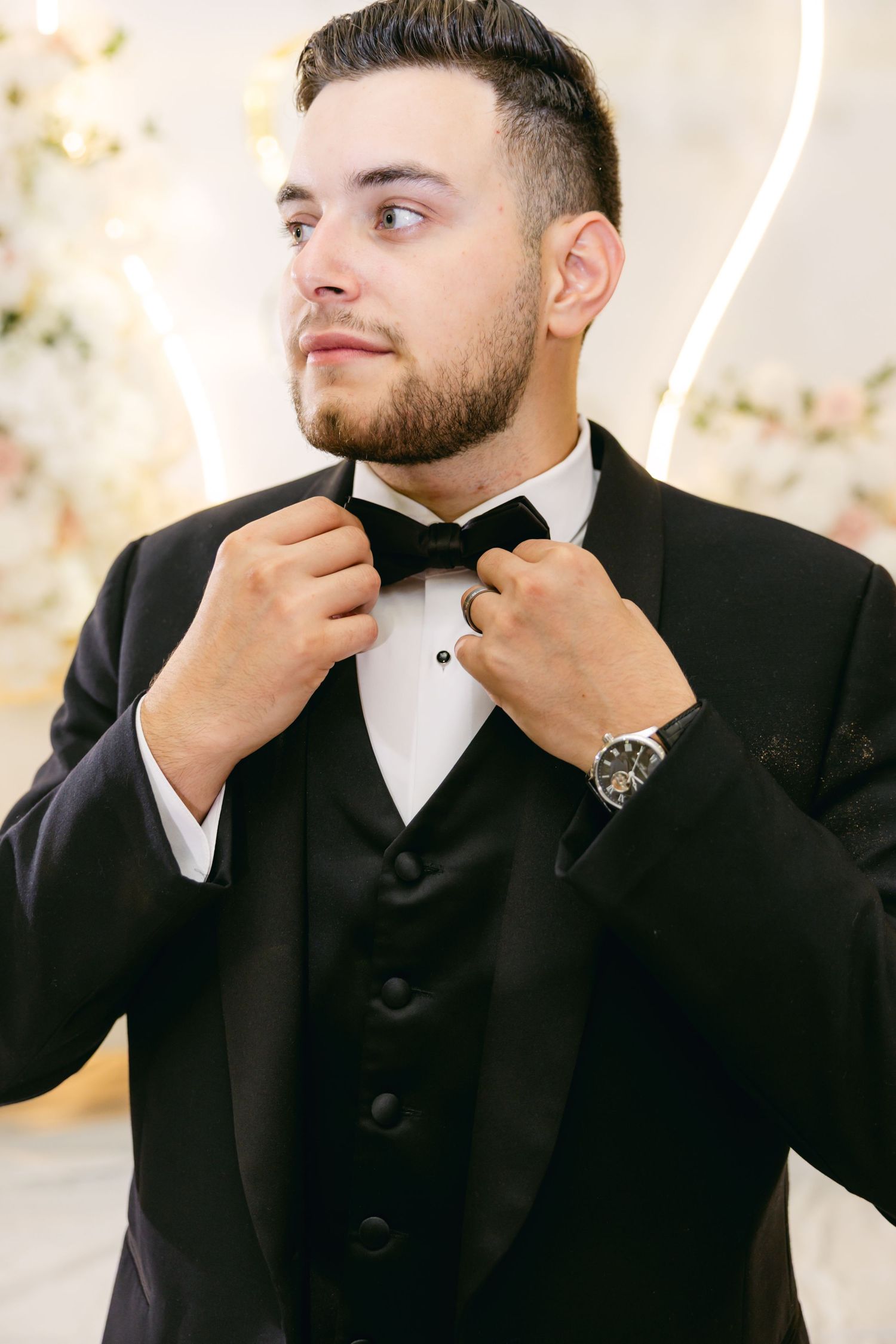 Groom in black tuxedo adjusting his bowtie in a sequence of photos.