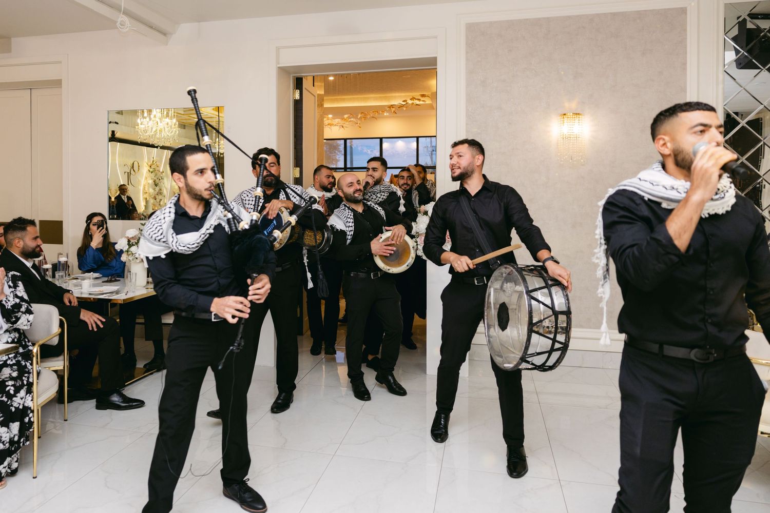 Wedding celebration featuring dancing and entertainment in an elegant white reception hall.