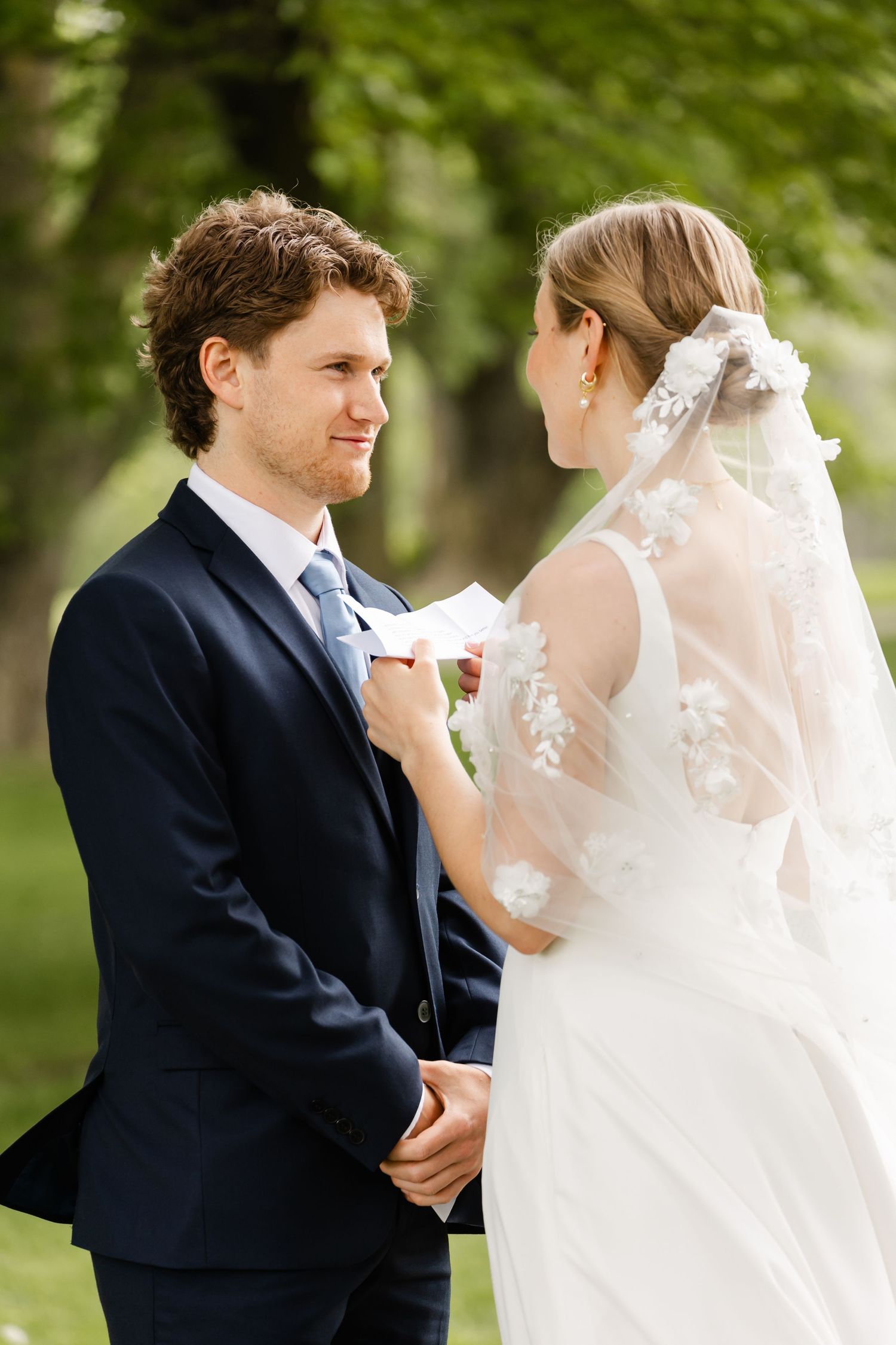 Sweet candid moment between couple during outdoor wedding first look photos.
