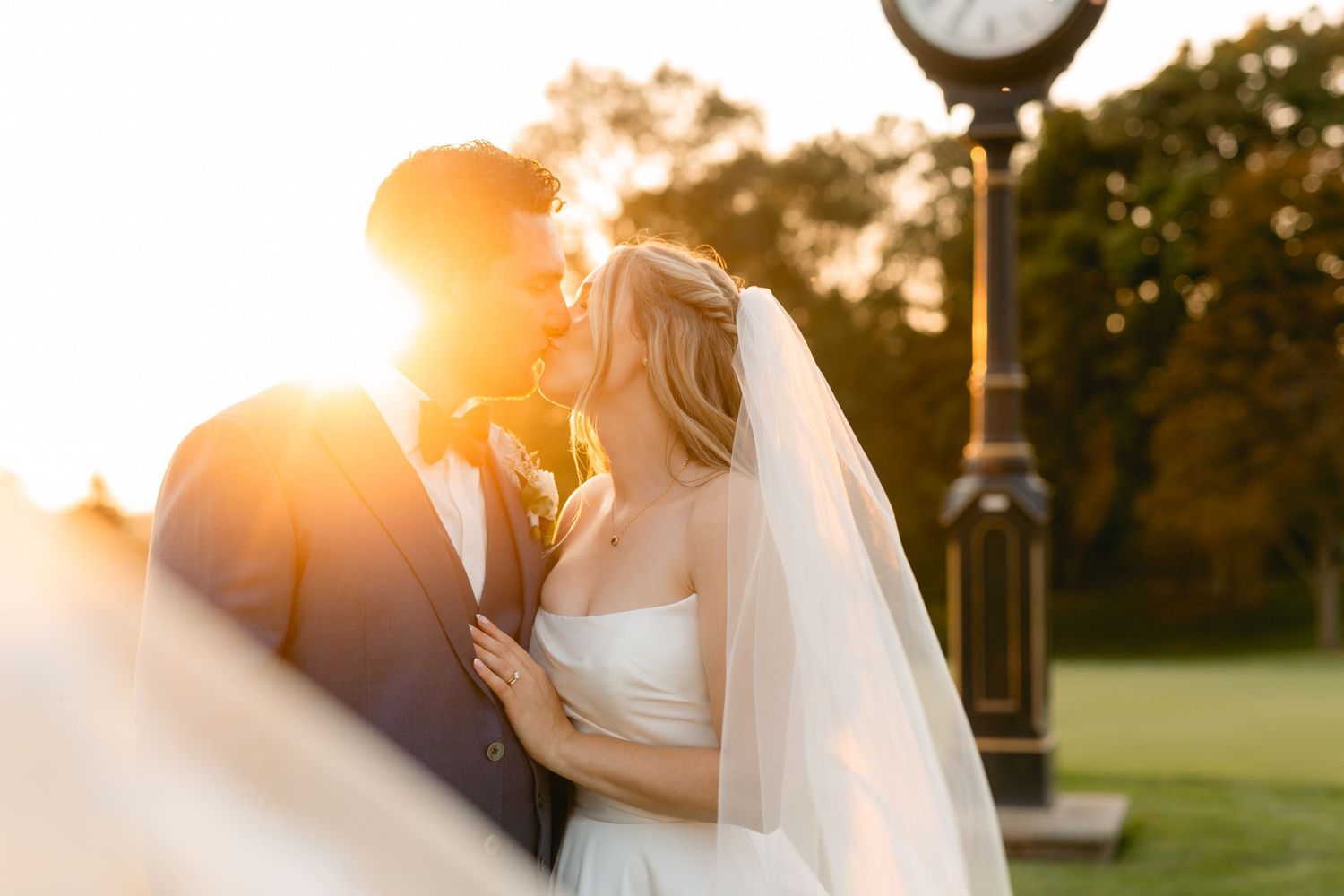 Sunset wedding portrait with golden light illuminating the couple's intimate moment.
