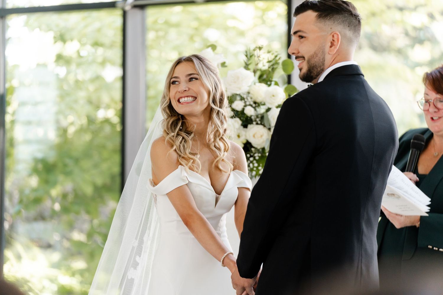 Emotional first look moment between couple at bright indoor wedding venue.