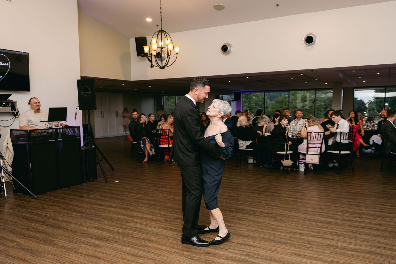 Wide view of wedding reception dance floor with guests celebrating.