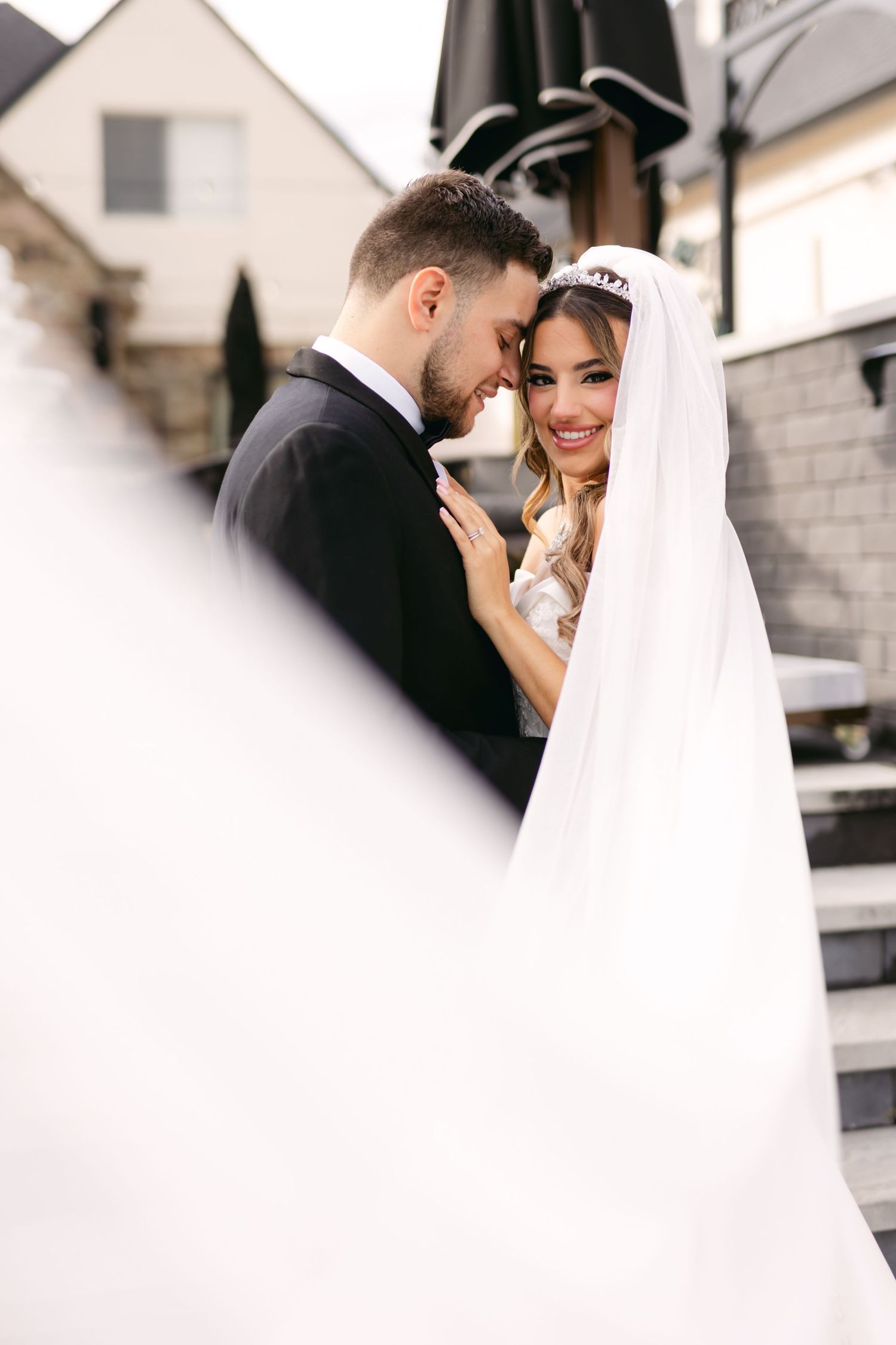 Romantic wedding moment captured in soft focus with flowing white veil.