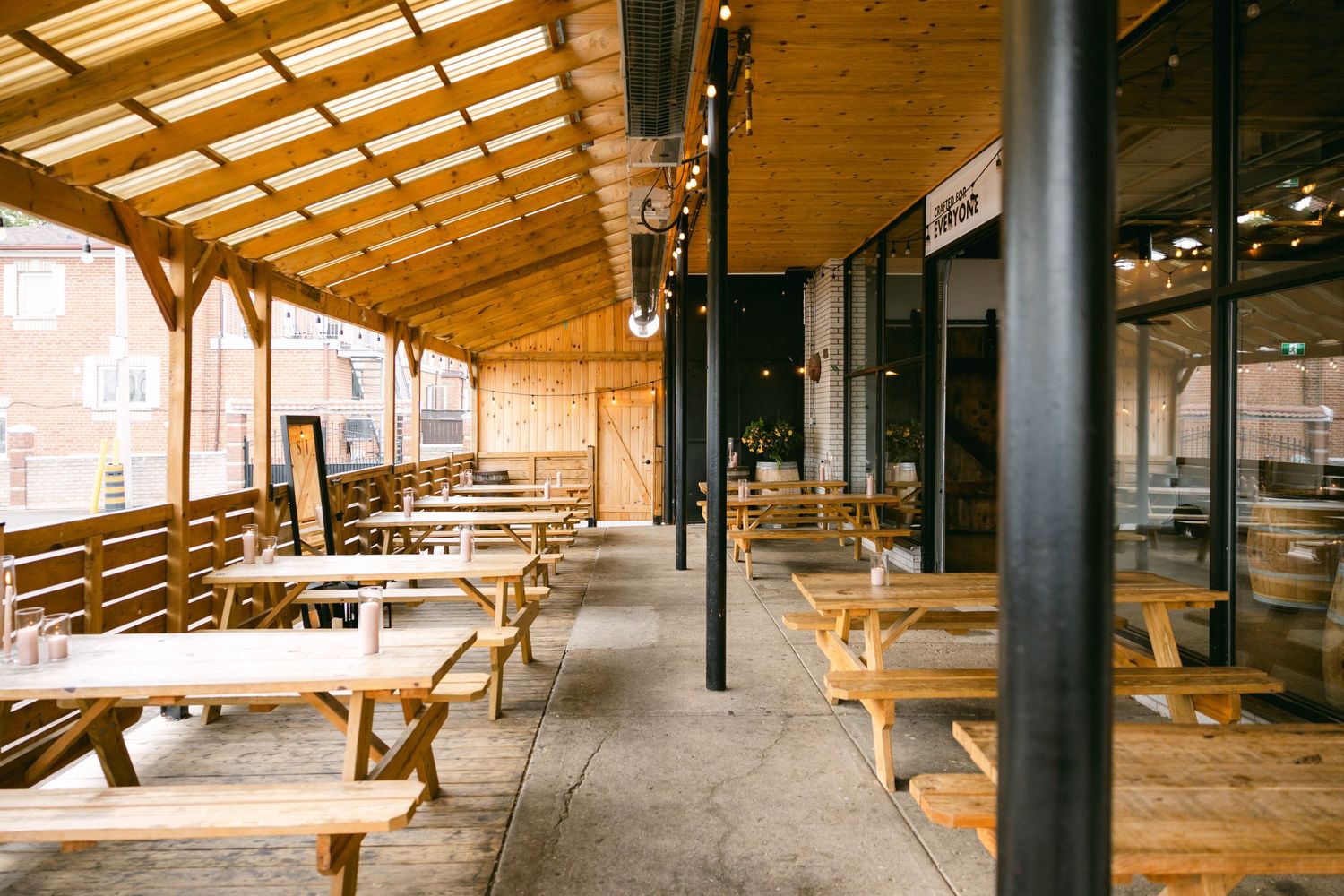 Open-air pavilion with wooden beams and metal support columns creating a covered gathering space.