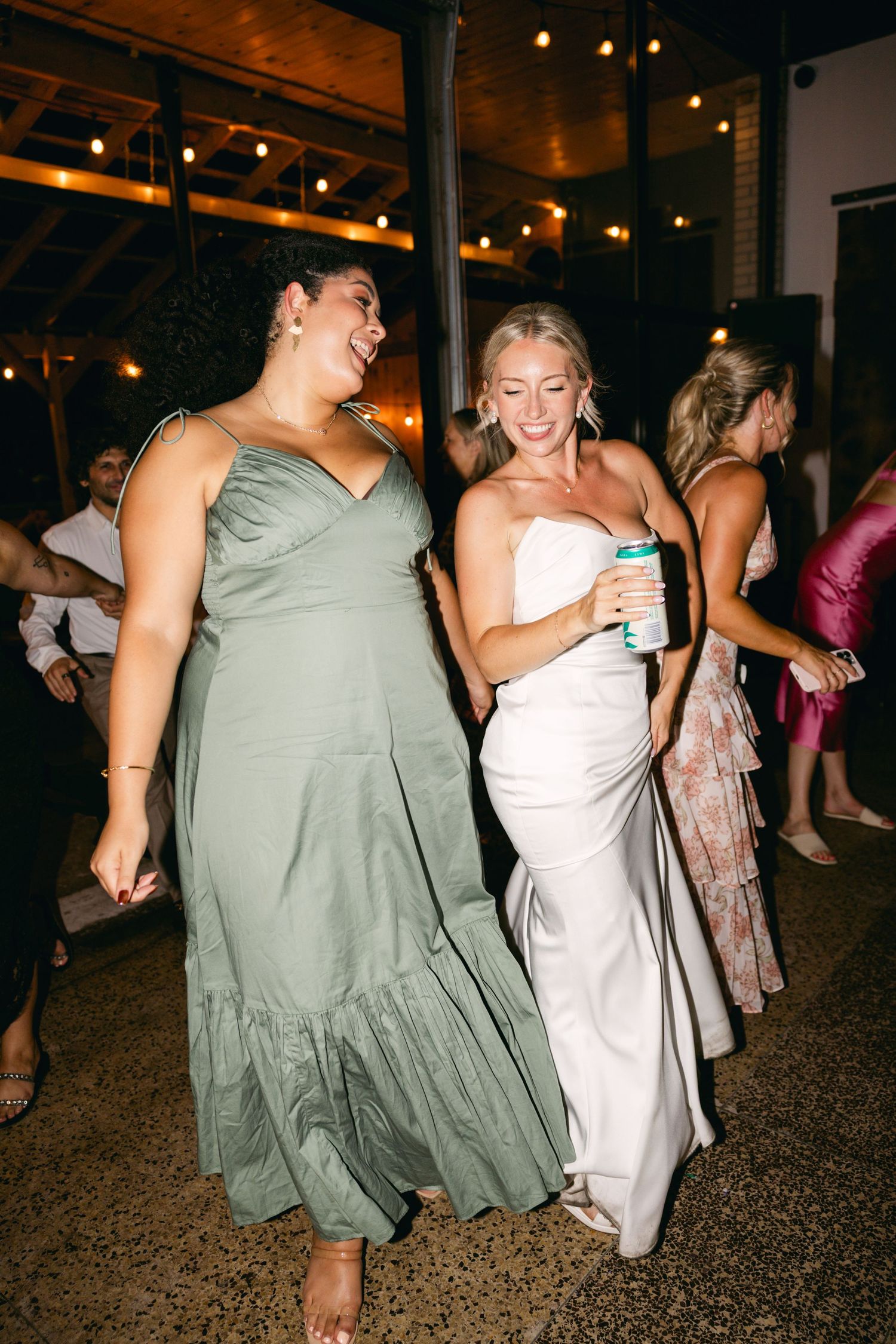 Wedding guests dancing in formal dresses during an evening reception.