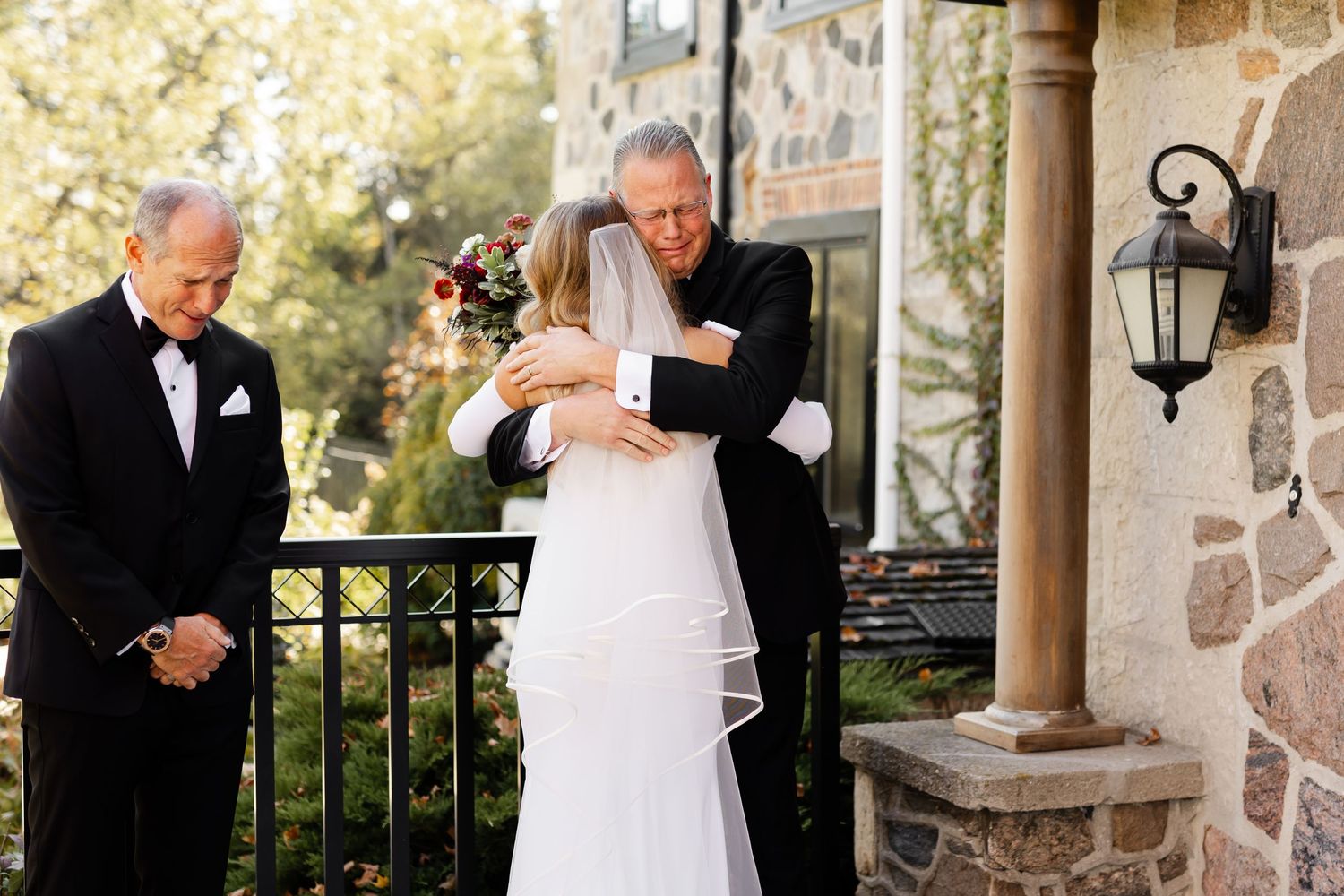 A romantic first look moment between newlyweds on their wedding day at a stone building venue.
