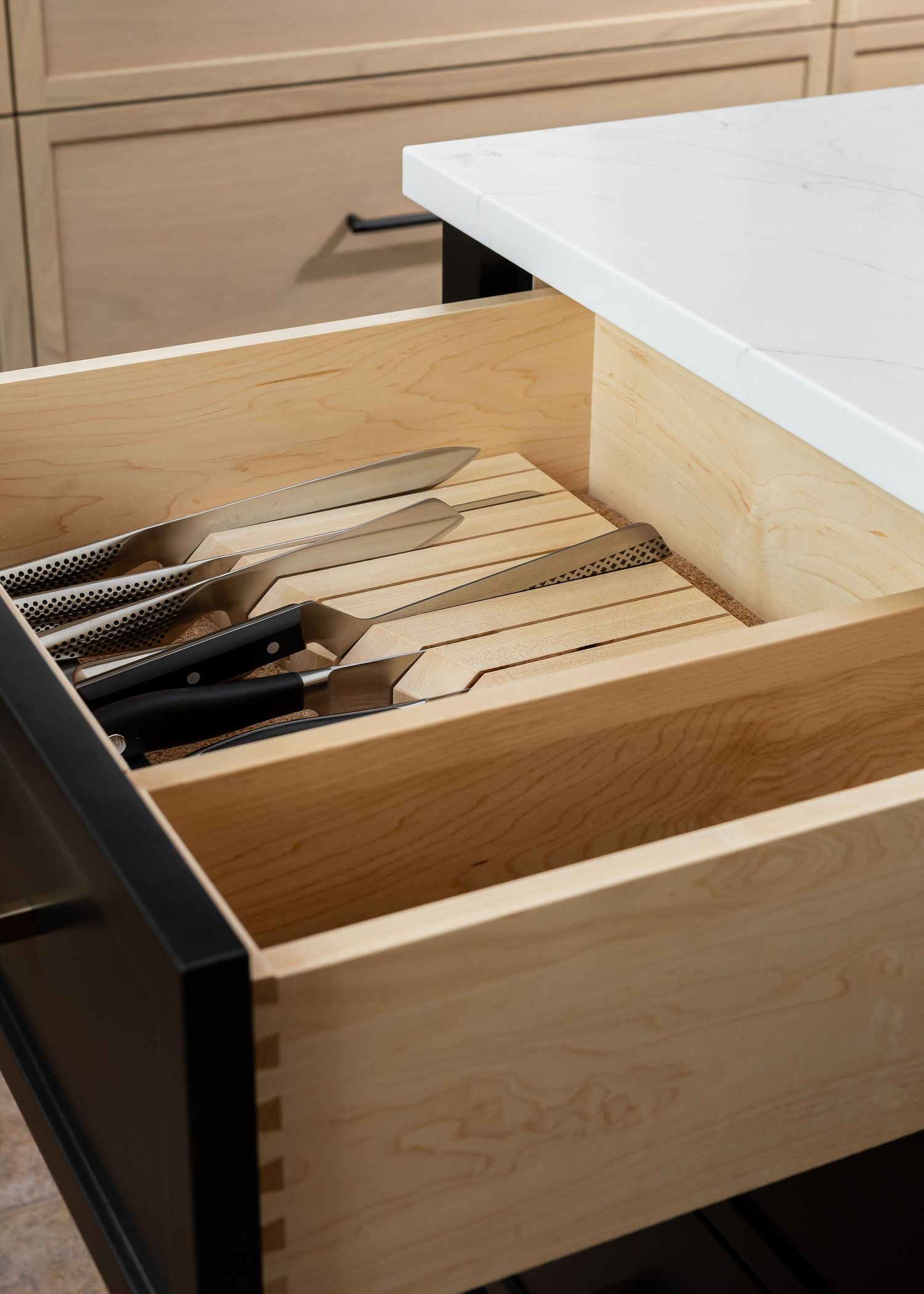 Custom wooden drawer organizer for kitchen utensils and knives.