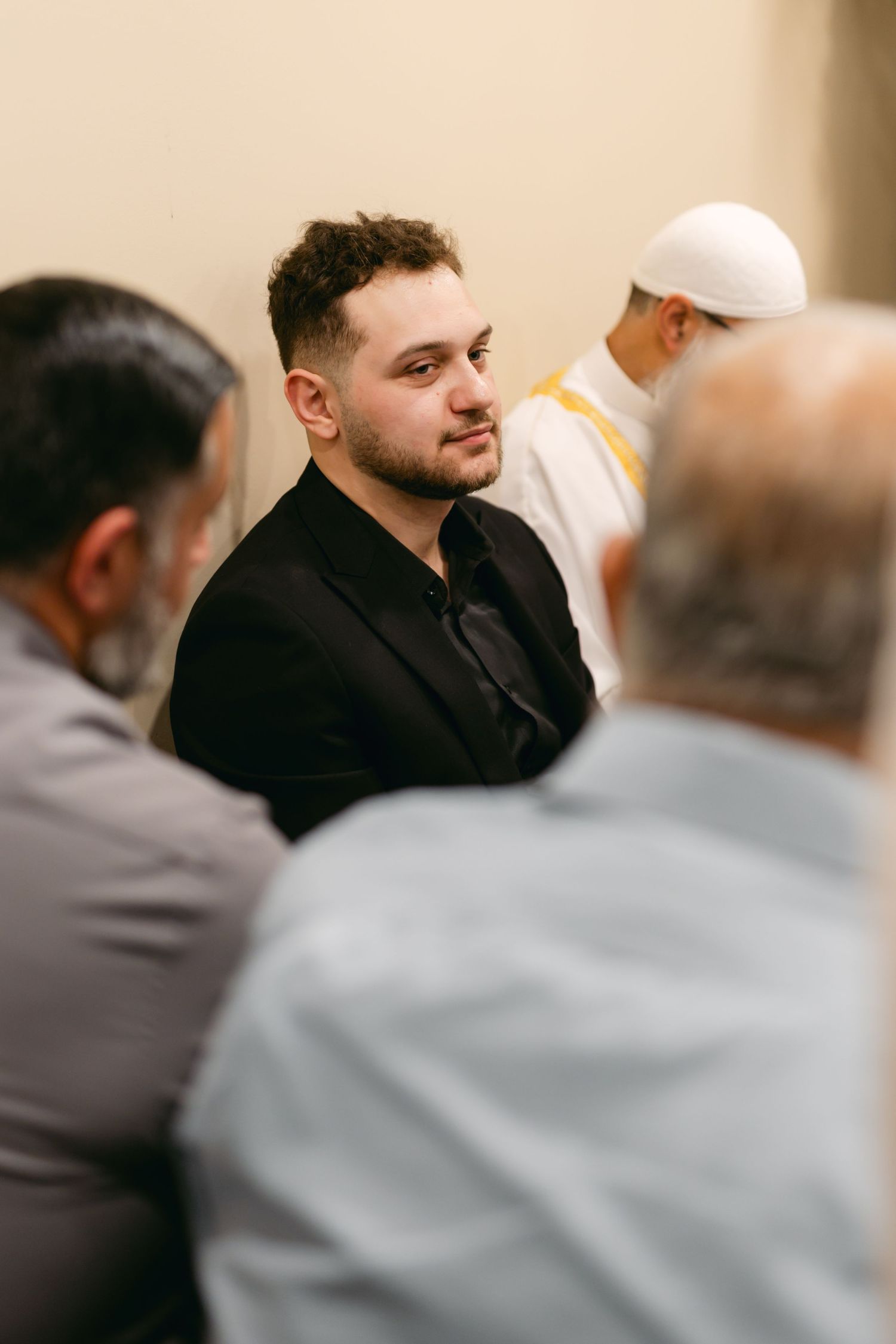 Attendees in formal attire engaged in conversation during an elegant indoor gathering.