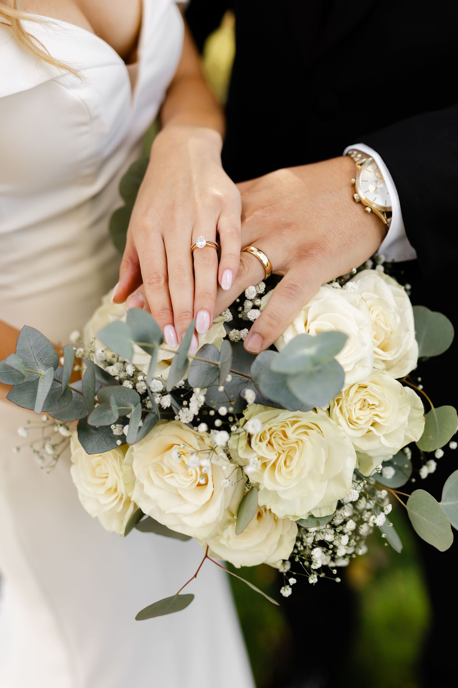 Elegant white roses and eucalyptus wedding bouquet with delicate details.