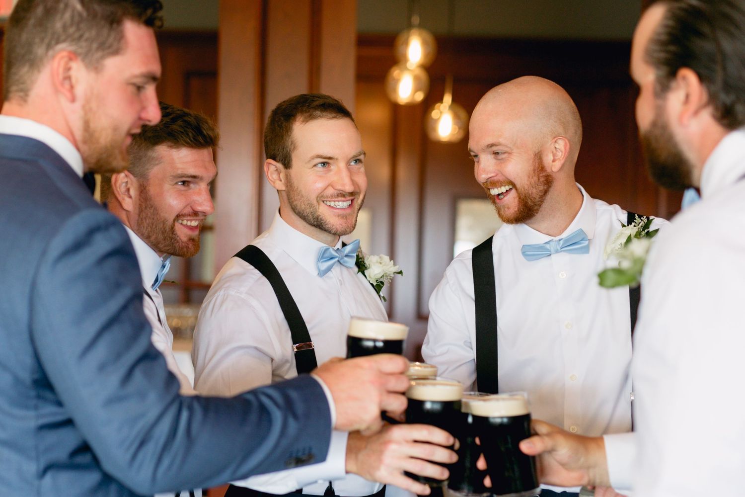 Wedding party members share drinks and laughter during pre-ceremony celebrations.