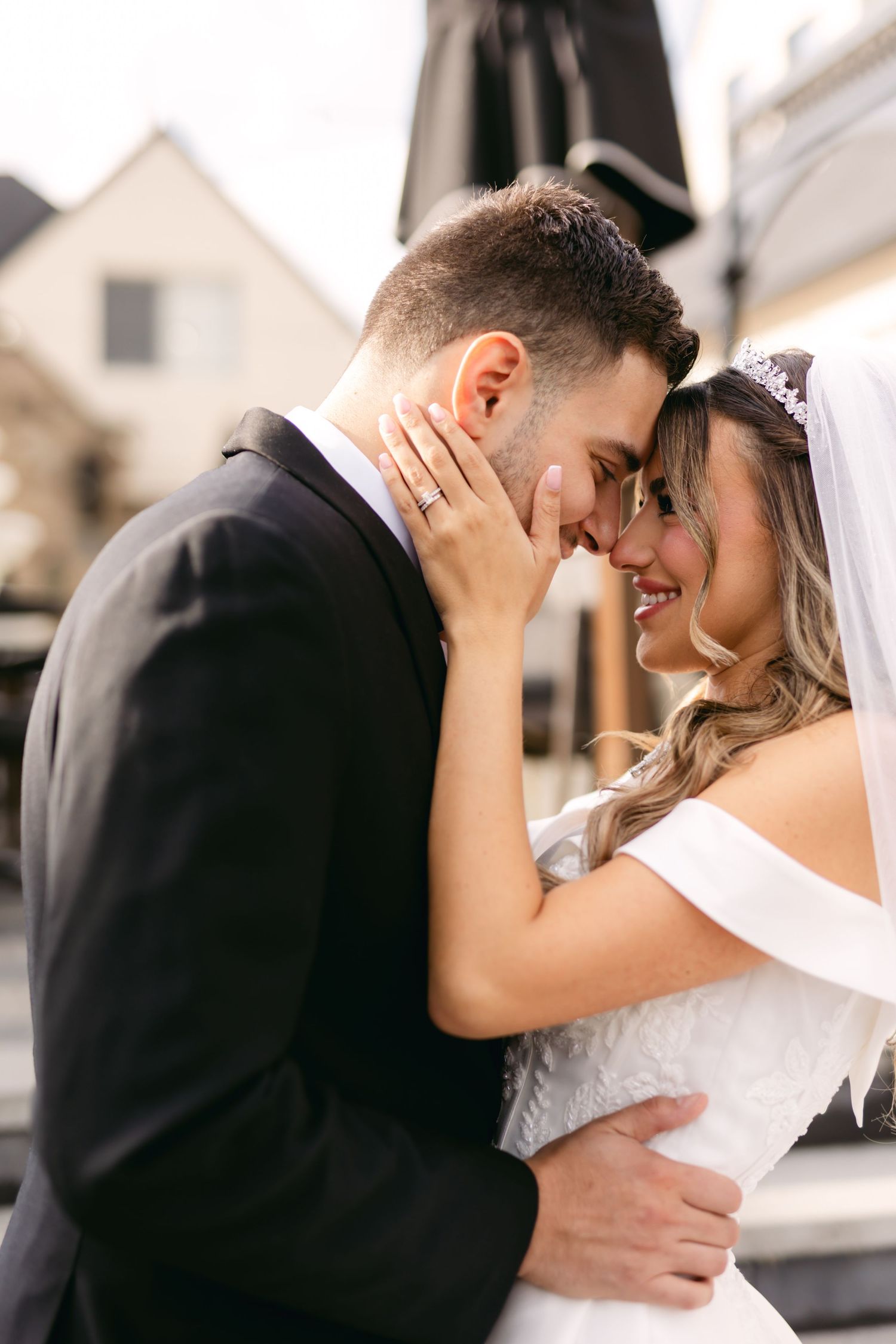 Intimate outdoor wedding portrait of couple sharing emotional moment.