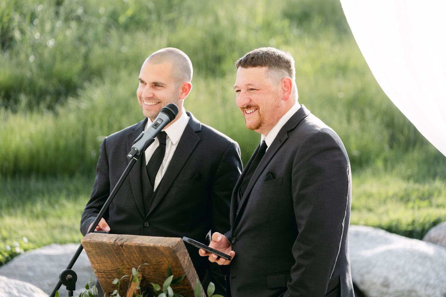 Groomsmen share laughs during outdoor wedding celebration.