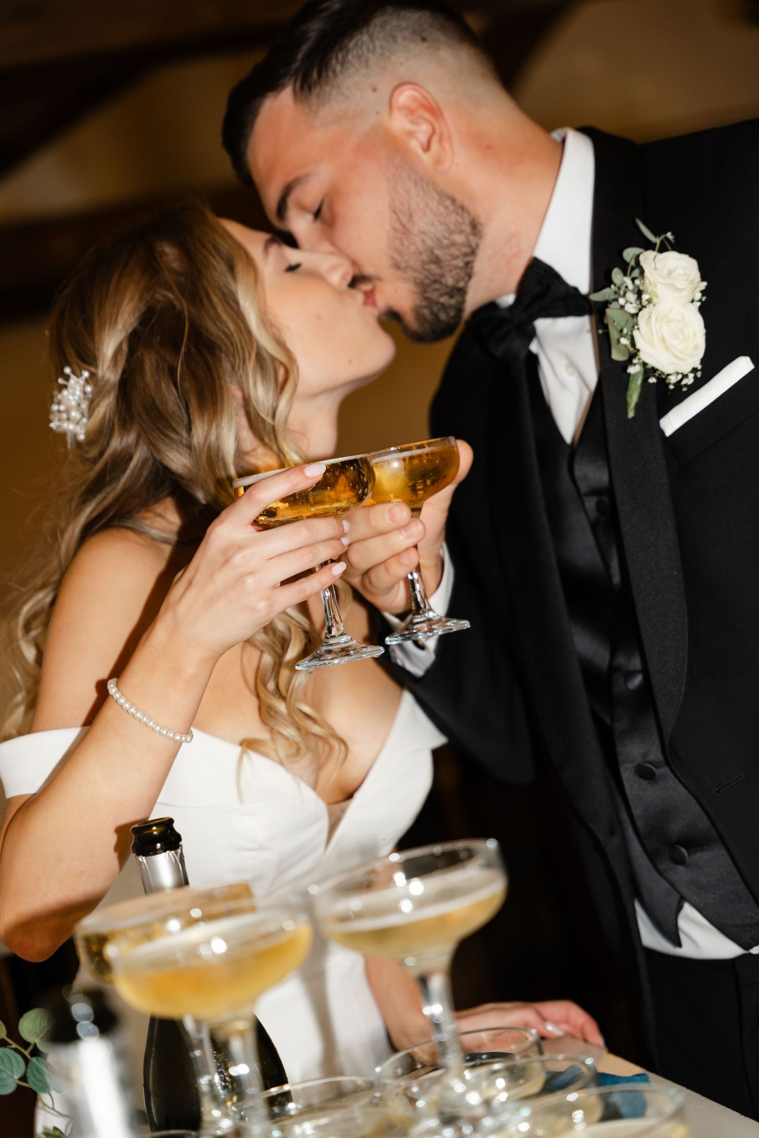 Romantic wedding celebration with couple enjoying champagne together near decorative glassware.