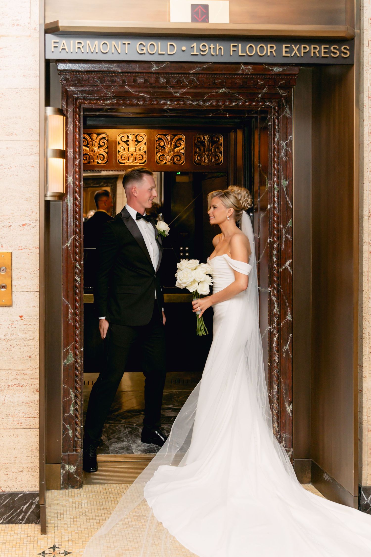 Bride and groom share a romantic moment in a elegant elevator entrance at Fairmont Gold 19th Floor.