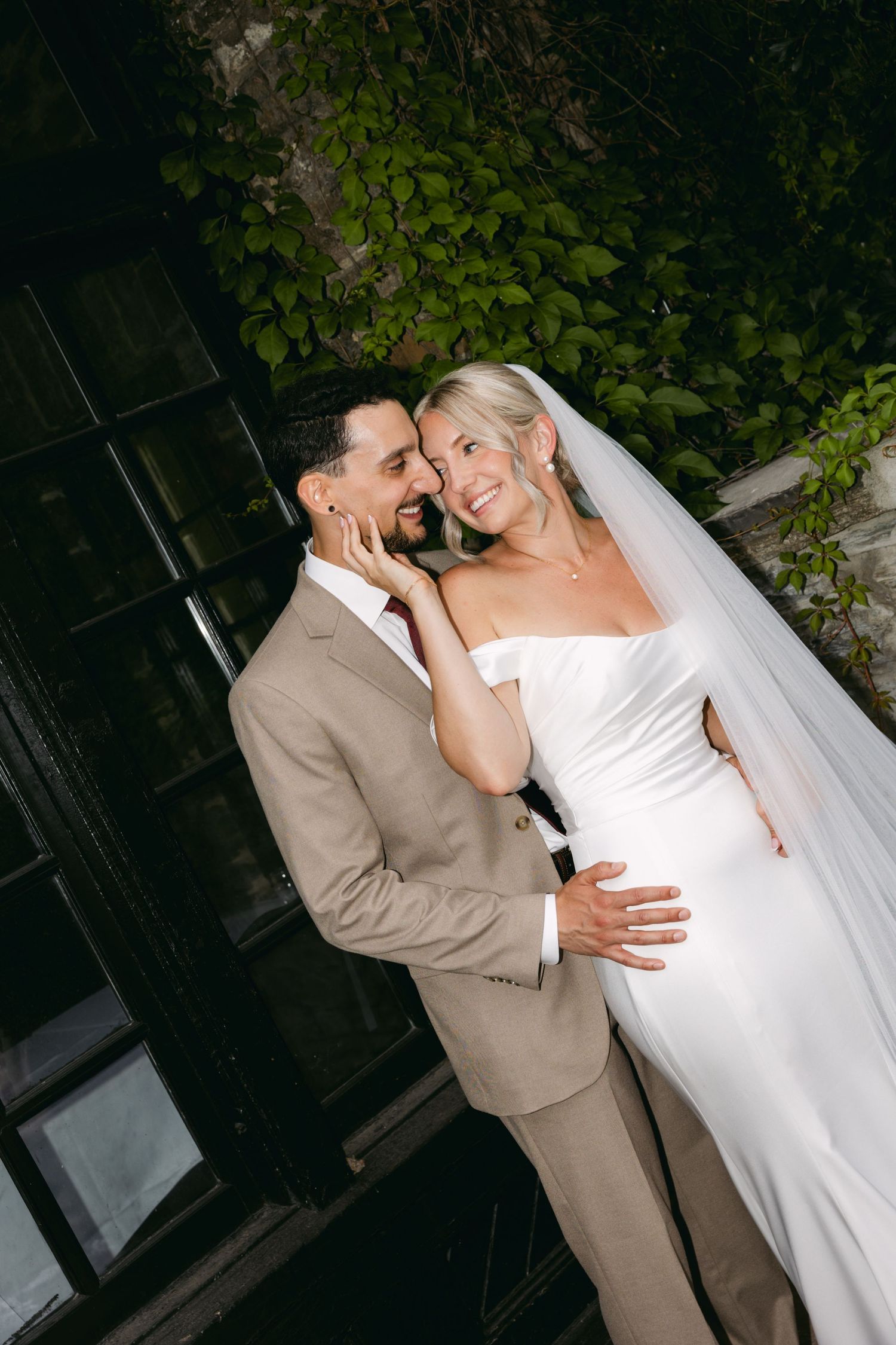 A romantic wedding photoshoot sequence showing tender moments between newlyweds against a dark background with greenery.
