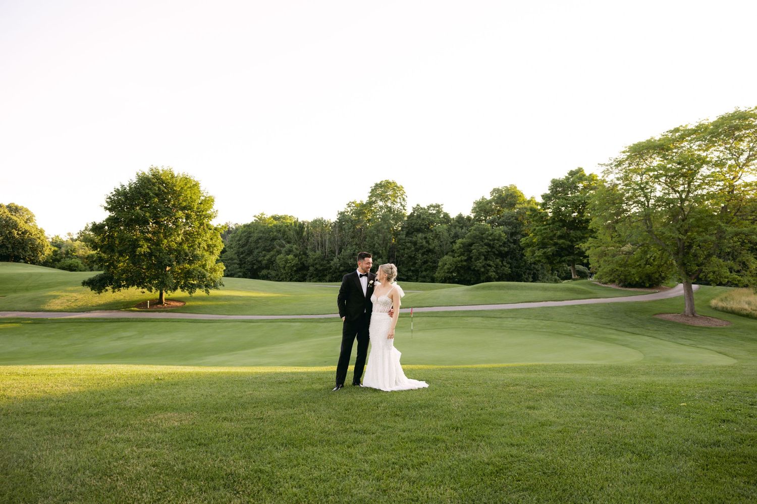 Wide landscape shots of a wedding couple on a scenic golf course at sunset.