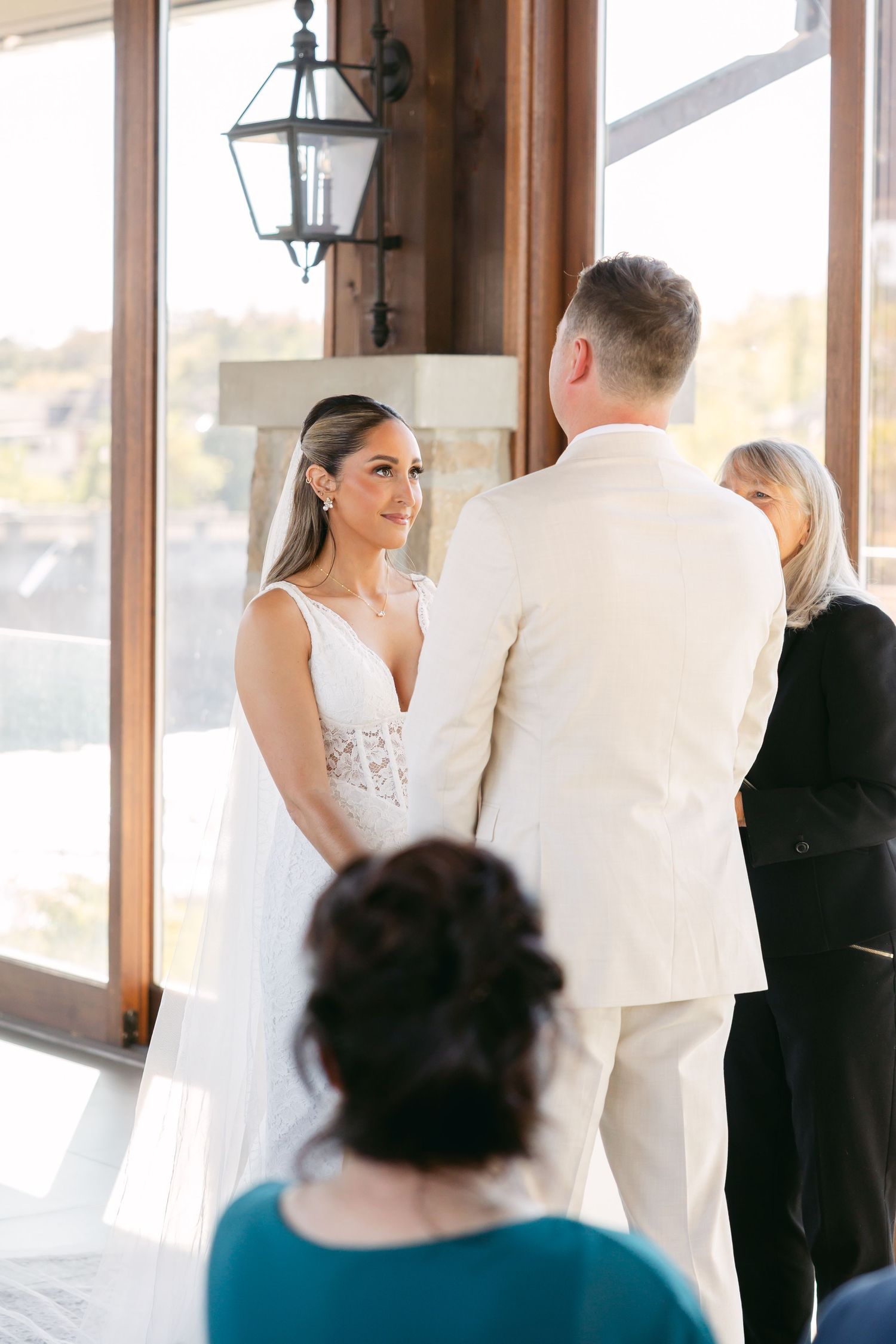 Intimate wedding ceremony moments captured in sunlit room with wooden beams.