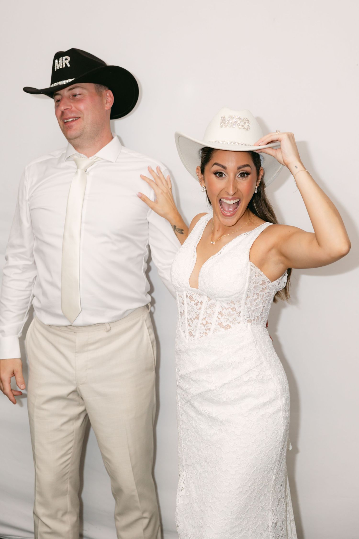 Wedding photo booth shots with cowboy hats and white formal attire.
