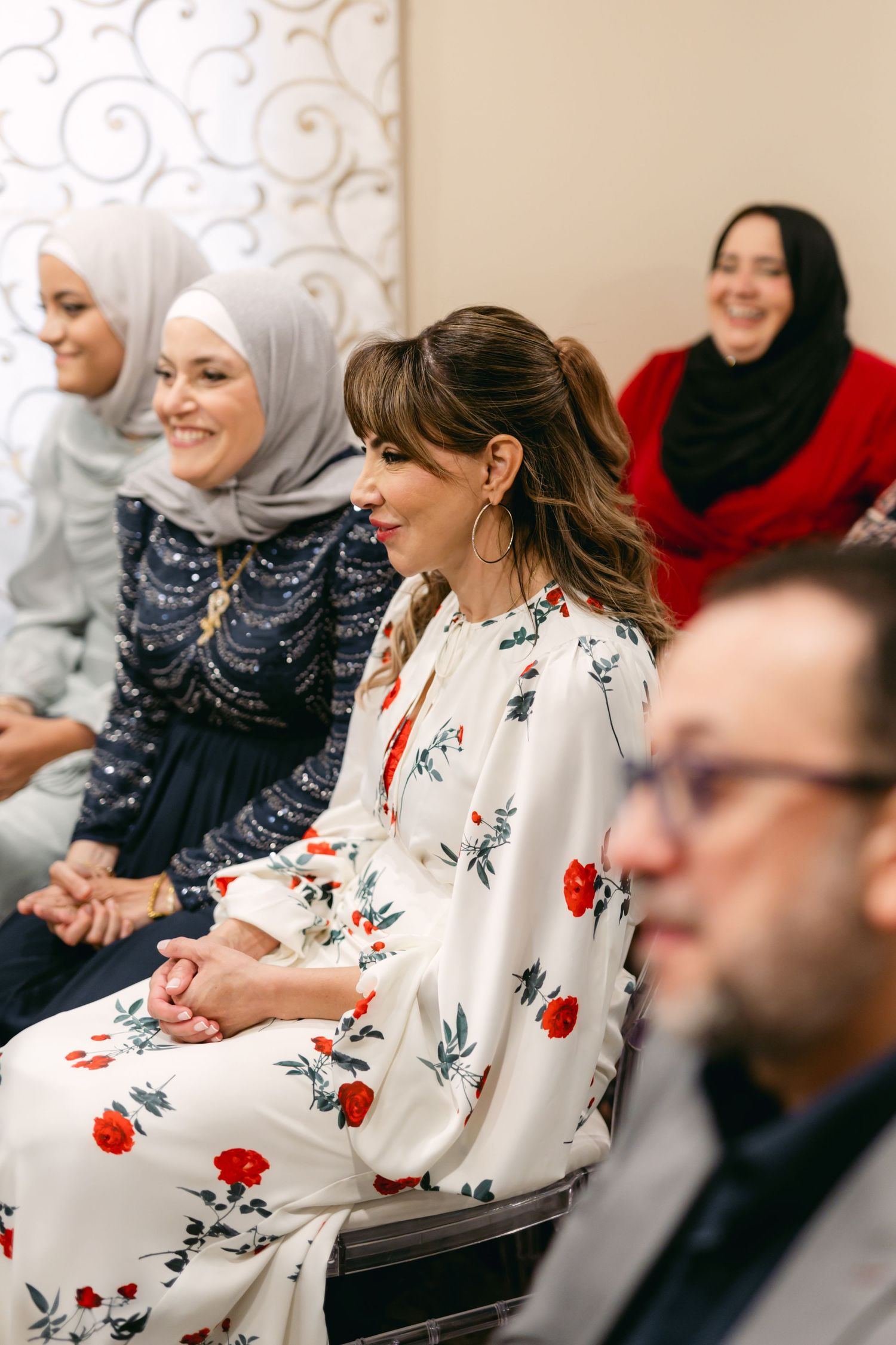 Guests in formal wear engaged in conversation at an elegant indoor celebration.