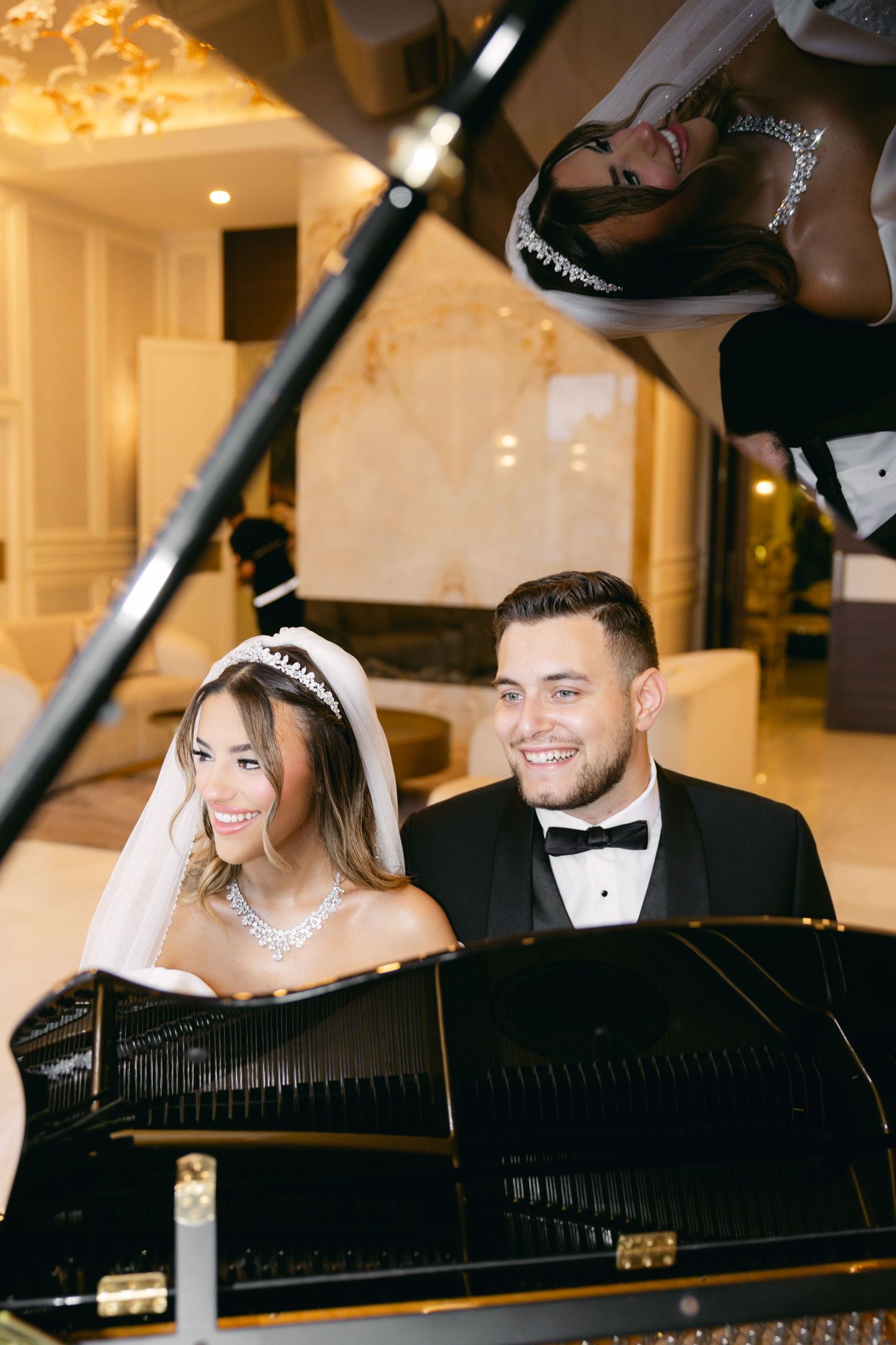 Romantic wedding photoshoot featuring couple at a grand piano in warm-lit elegant setting.