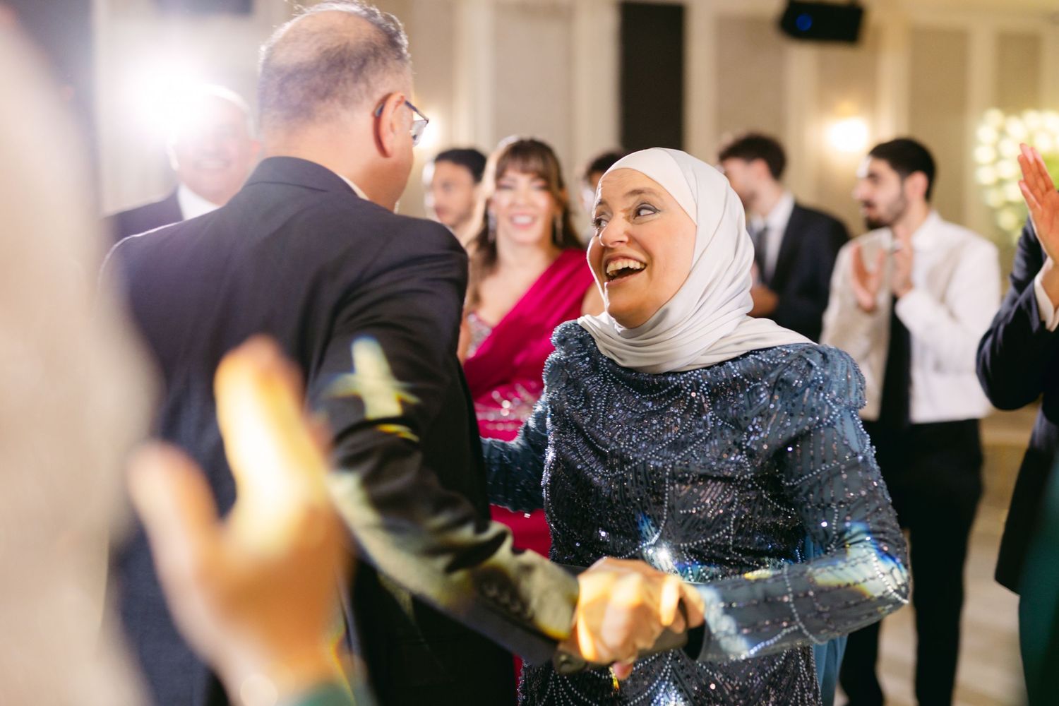 Wedding guests share a joyful dance moment at an elegant reception.