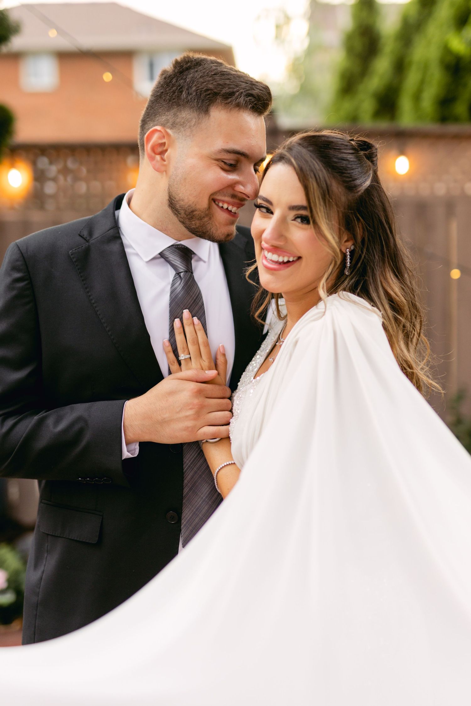 Romantic wedding couple sharing tender moment in backyard garden setting.