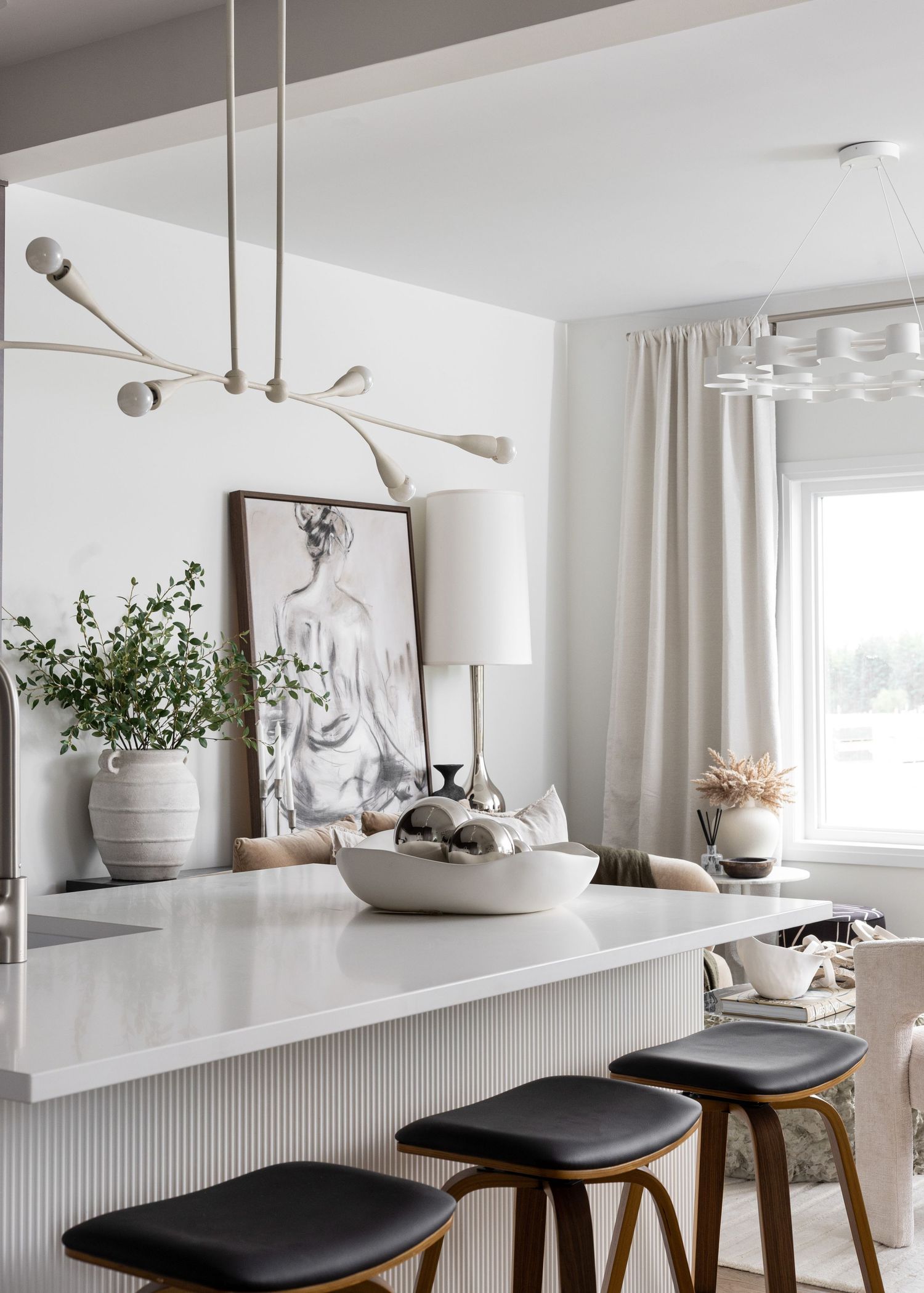 Stylish dining area with black leather stools, white shelving and modern lighting fixtures.