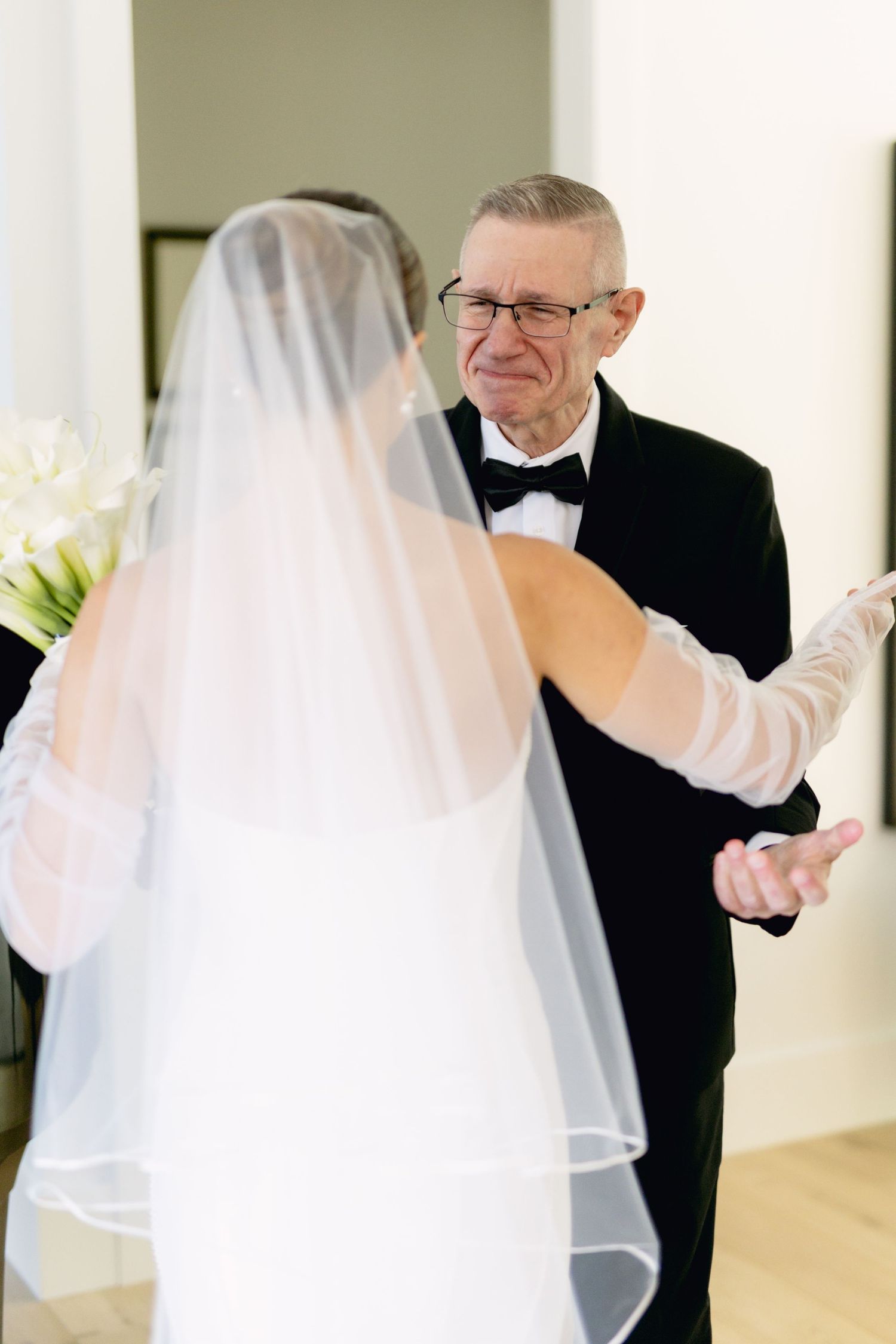 Emotional father sees bride for first time during wedding day first look moment.