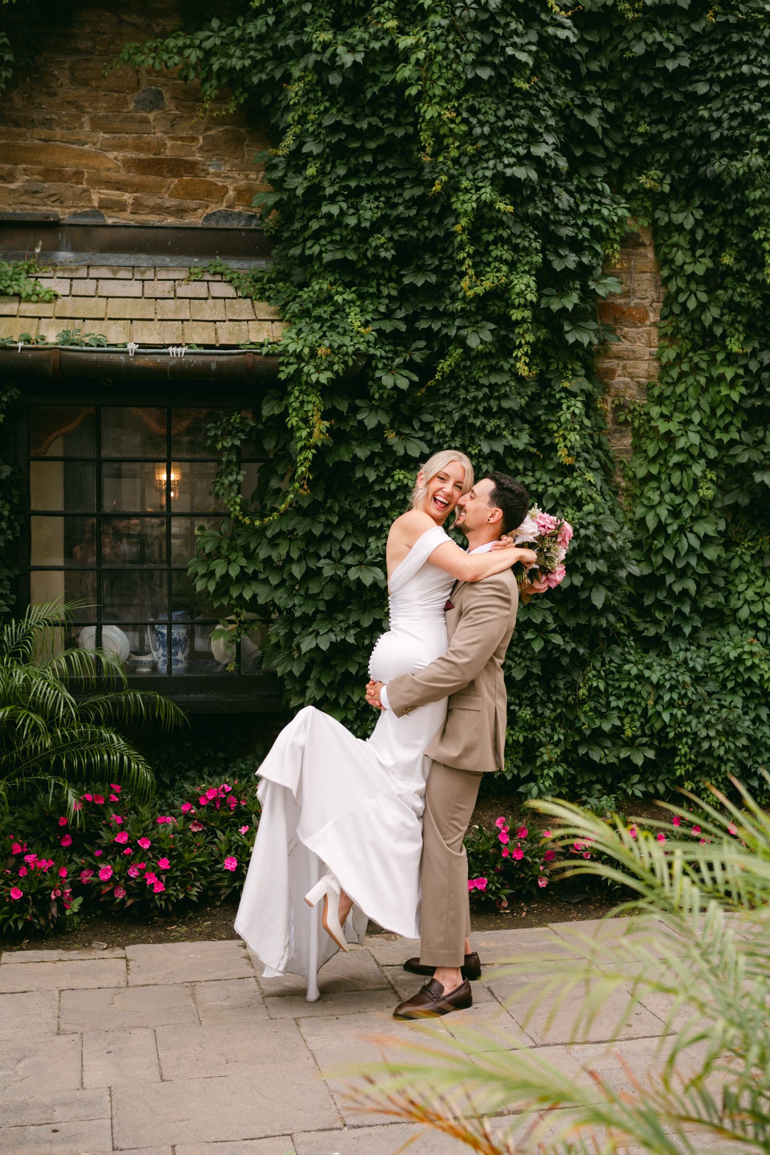 Playful wedding portraits taken against a backdrop of climbing ivy and stone walls.
