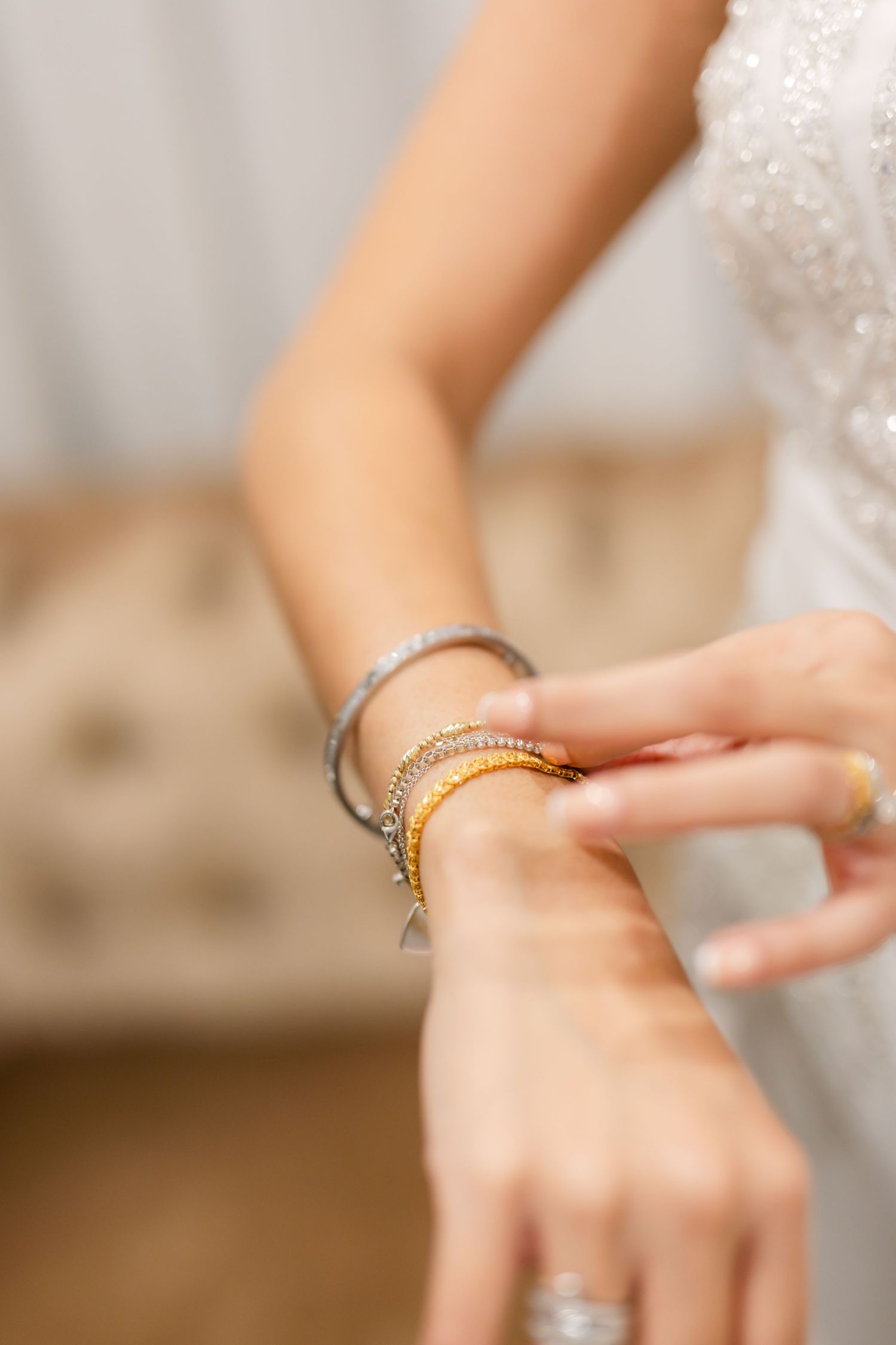 Close-up view of delicate jewelry and accessories being put on during wedding preparations.