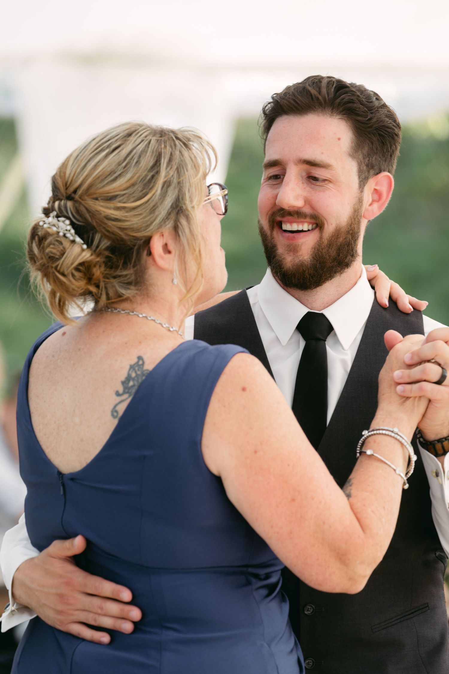 Emotional wedding moment captured between two people in formal attire sharing laughter and embraces.