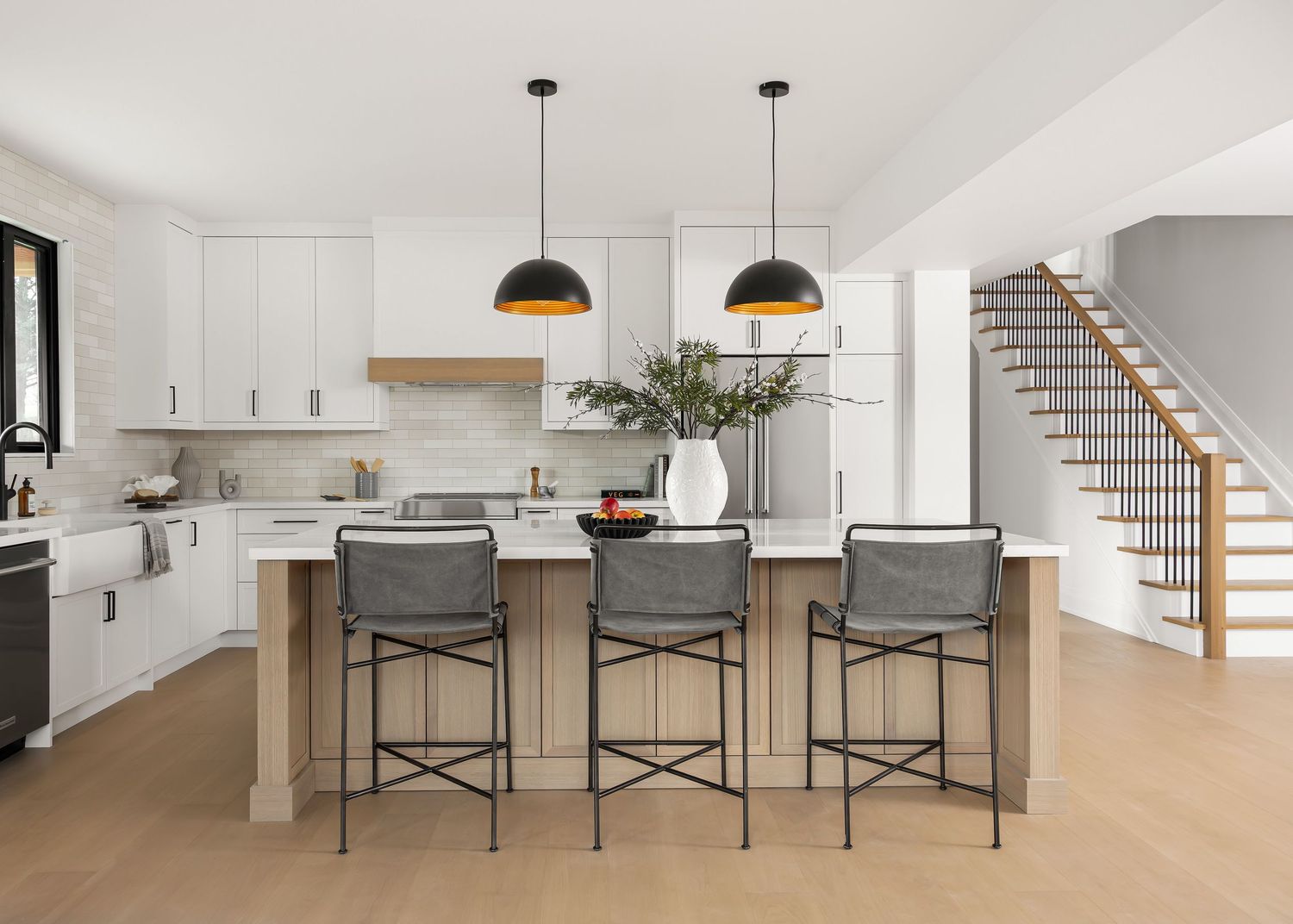 Open concept kitchen and dining area with minimalist design and pendant lighting.