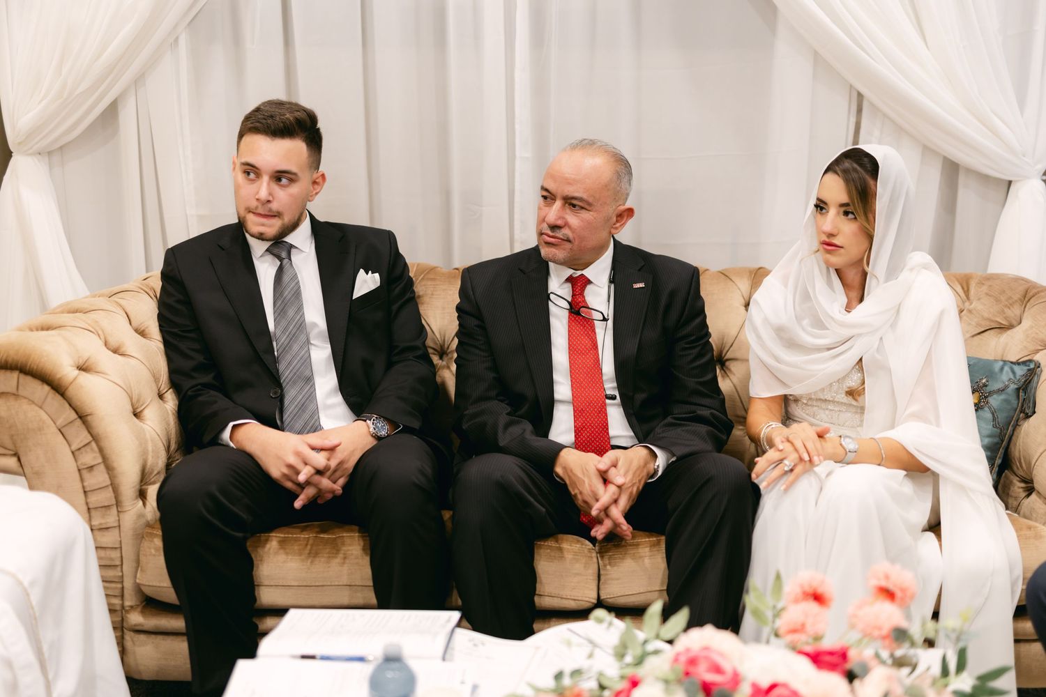 Attendees seated in formal attire at an elegant indoor celebration.