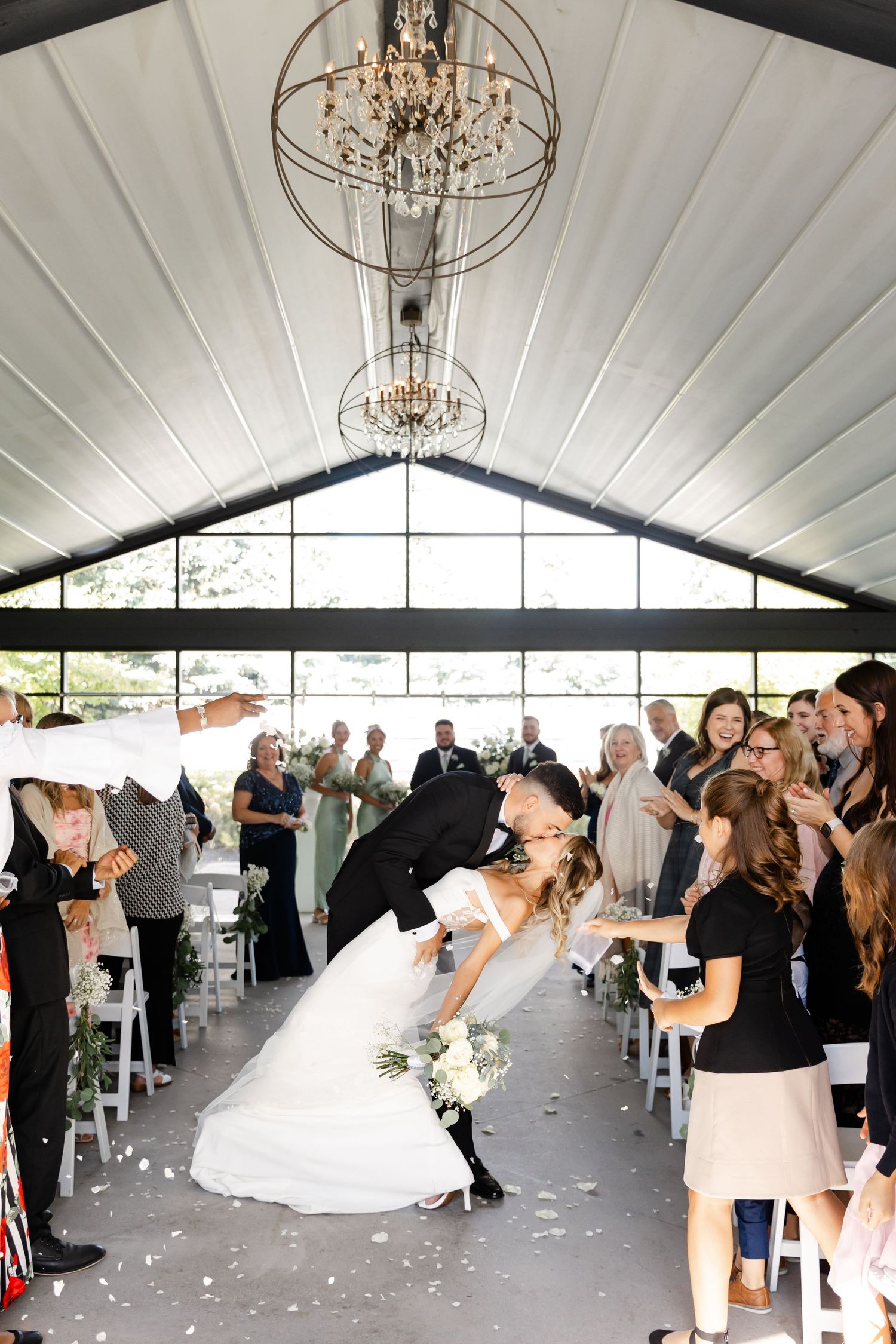 Wedding reception venue decorated with elegant chandeliers and guests dancing on the dance floor.