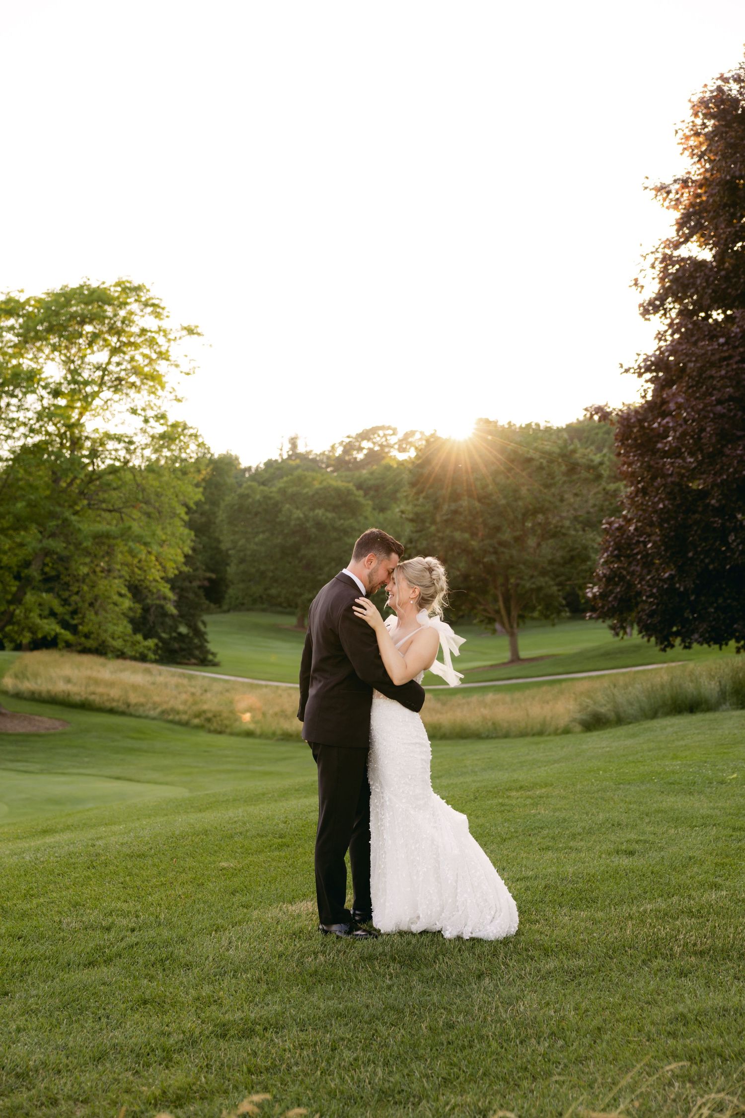 Sunset wedding photos showing intimate moments on a scenic golf course.