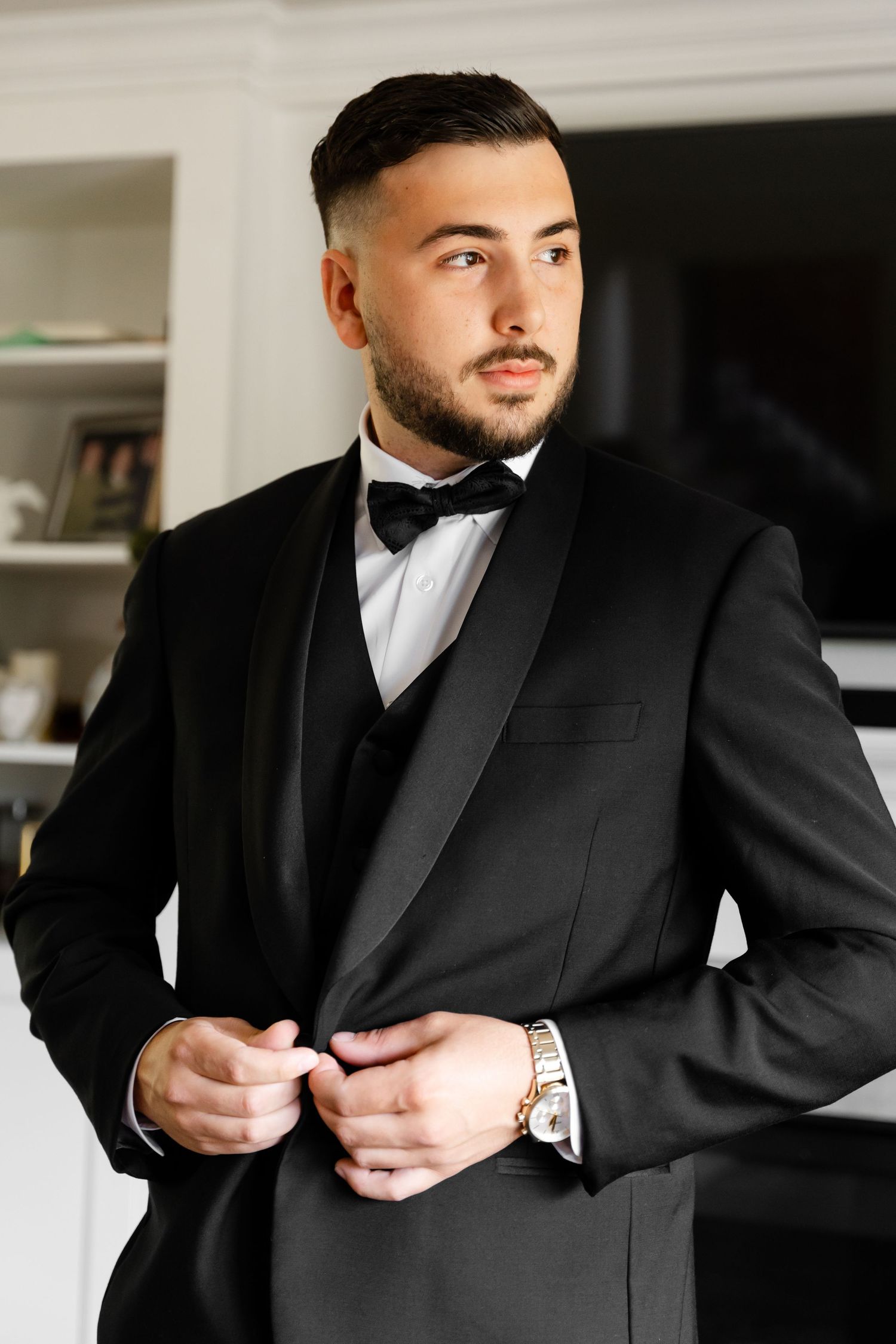 Detail shots of a groom getting ready and adjusting his formal black tuxedo.