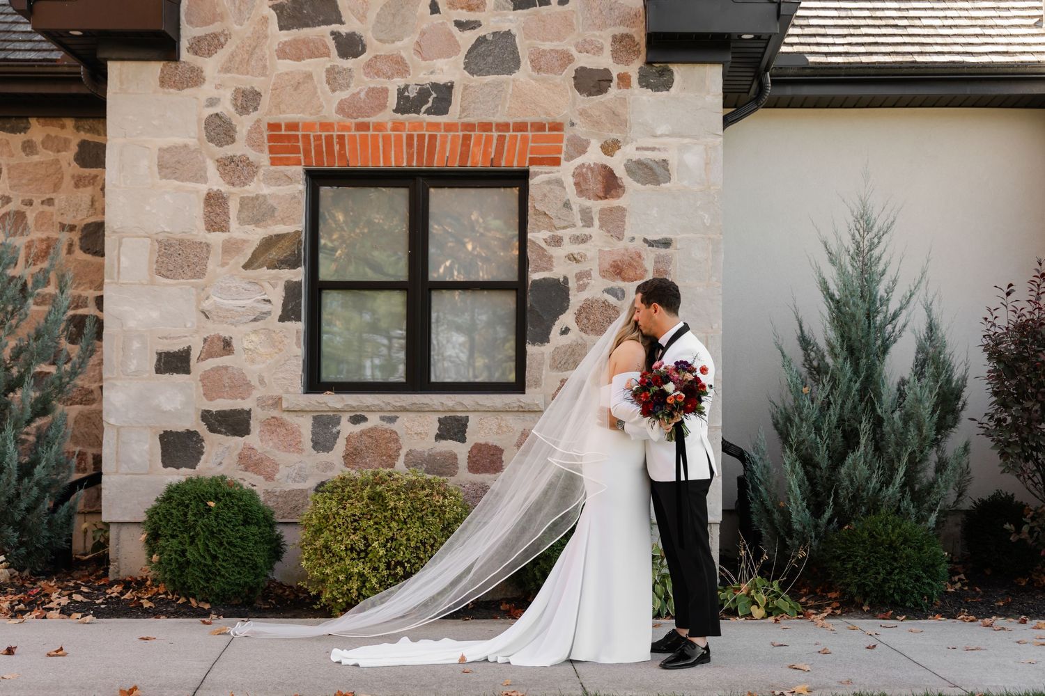 A wedding first look sequence captured against a rustic stone building exterior.