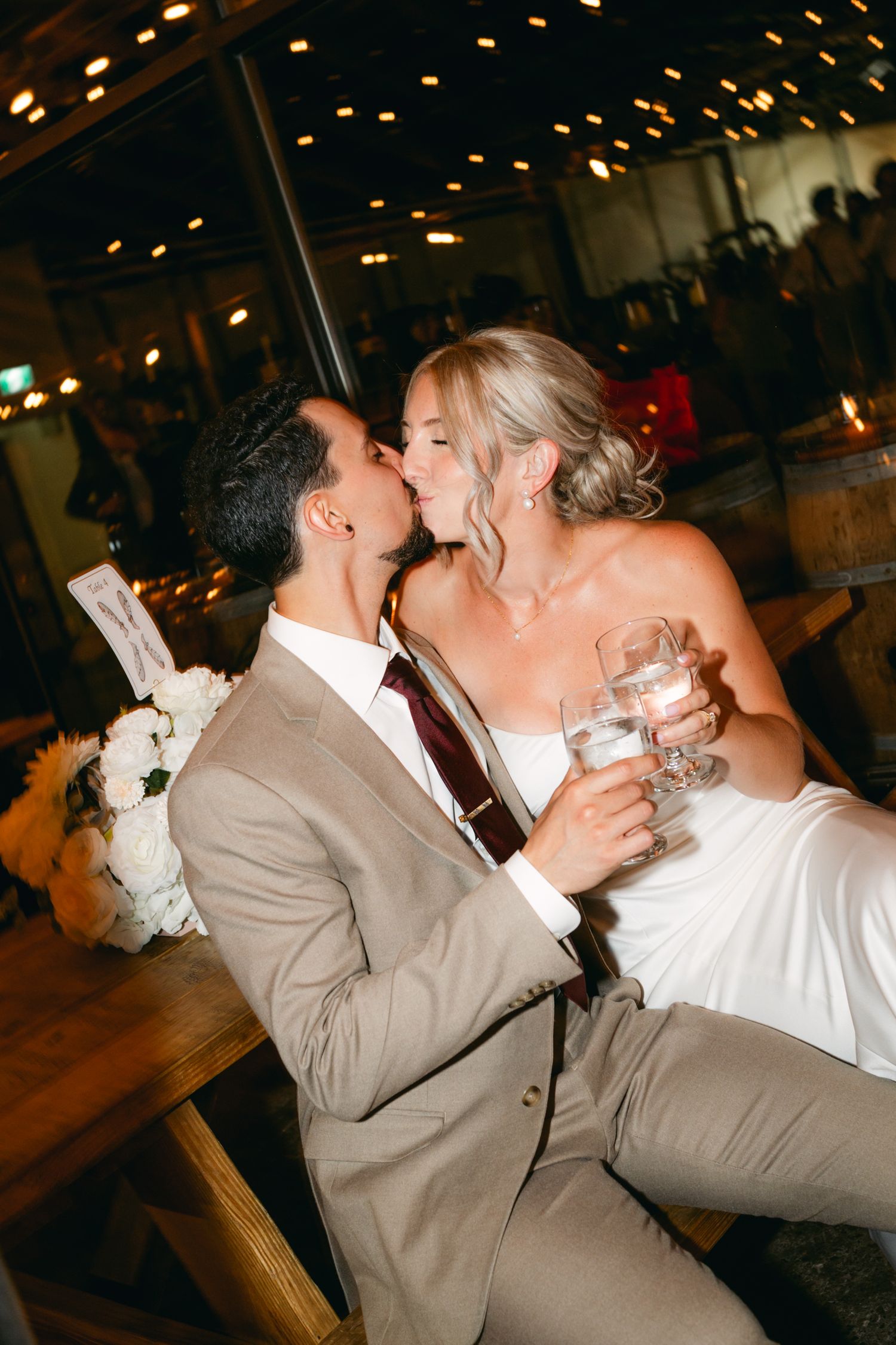 Romantic wedding couple sharing a passionate kiss during their reception celebration.