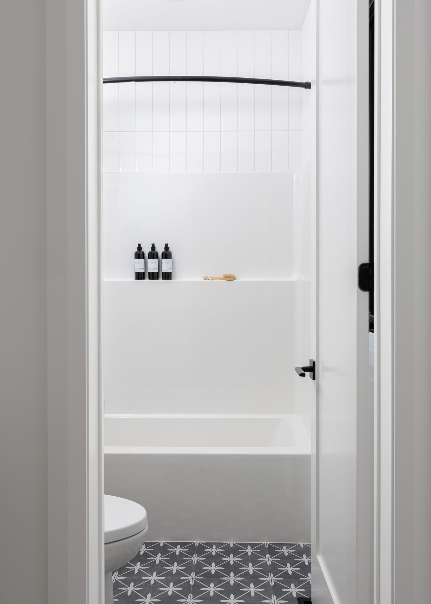 Minimalist bathroom design with geometric floor tiles and white walls showcases clean, modern aesthetics.