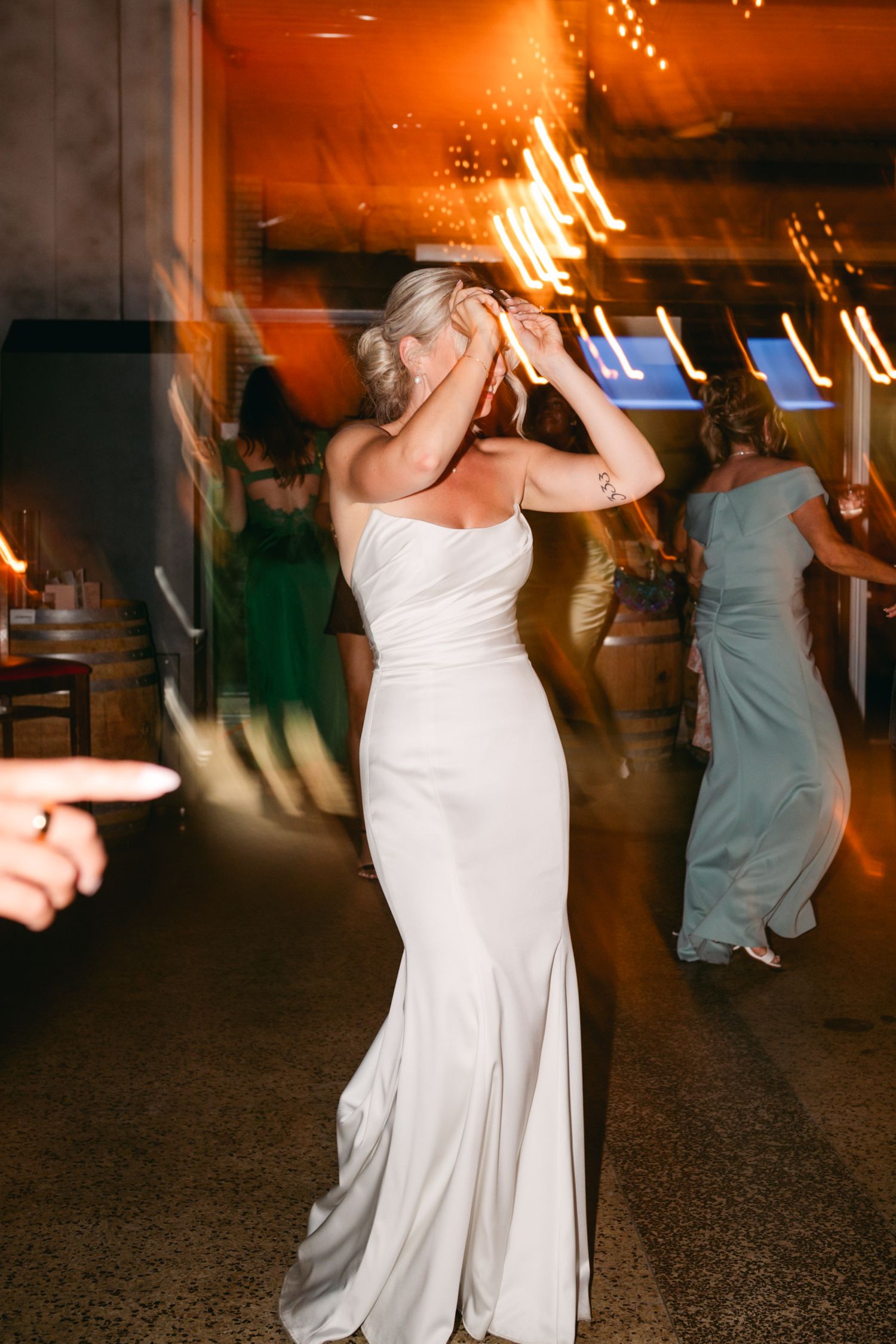 Dance floor illuminated with warm lighting showing motion blur of dancers in evening celebration.