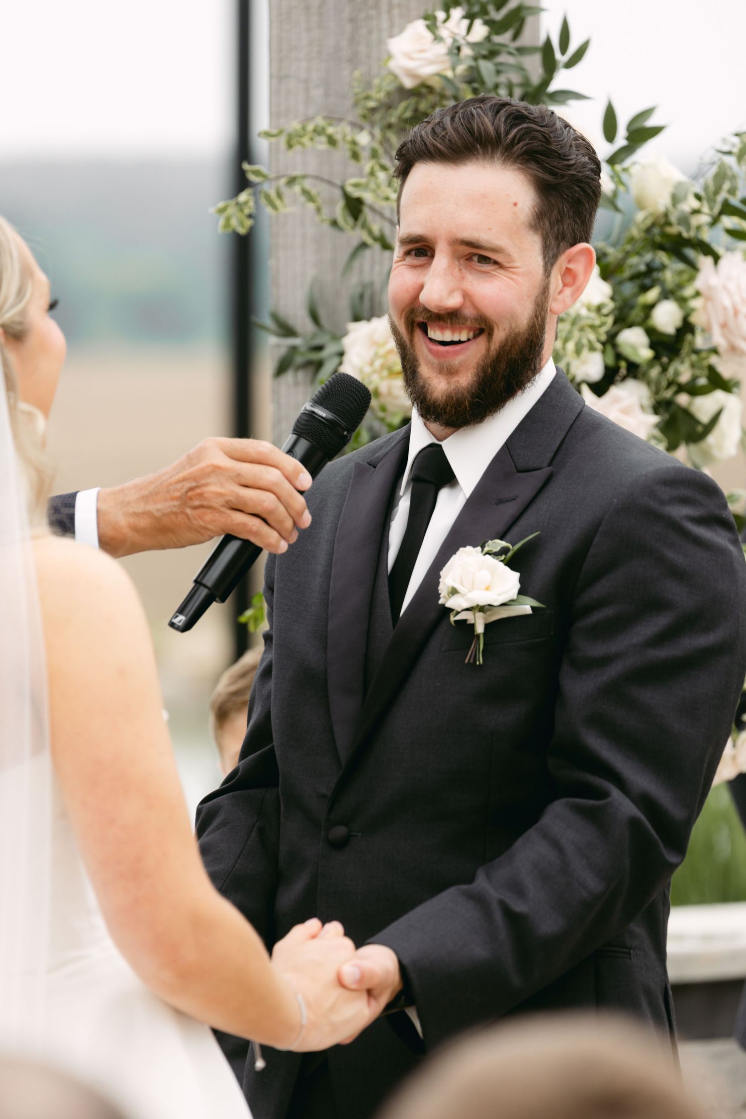 Emotional wedding ceremony moments captured under a floral-decorated pergola.