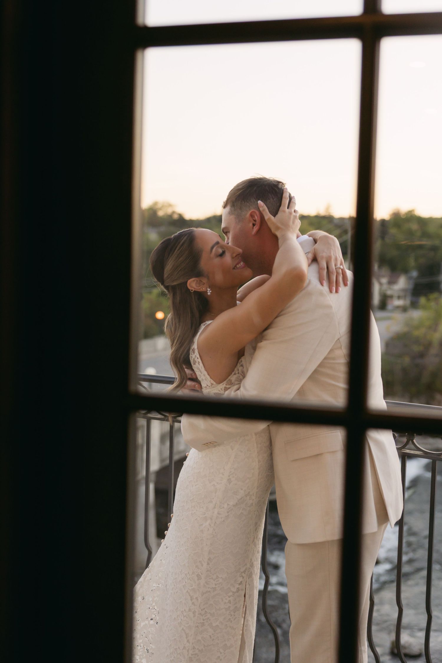 Silhouetted couple embracing by a window during an intimate wedding moment.