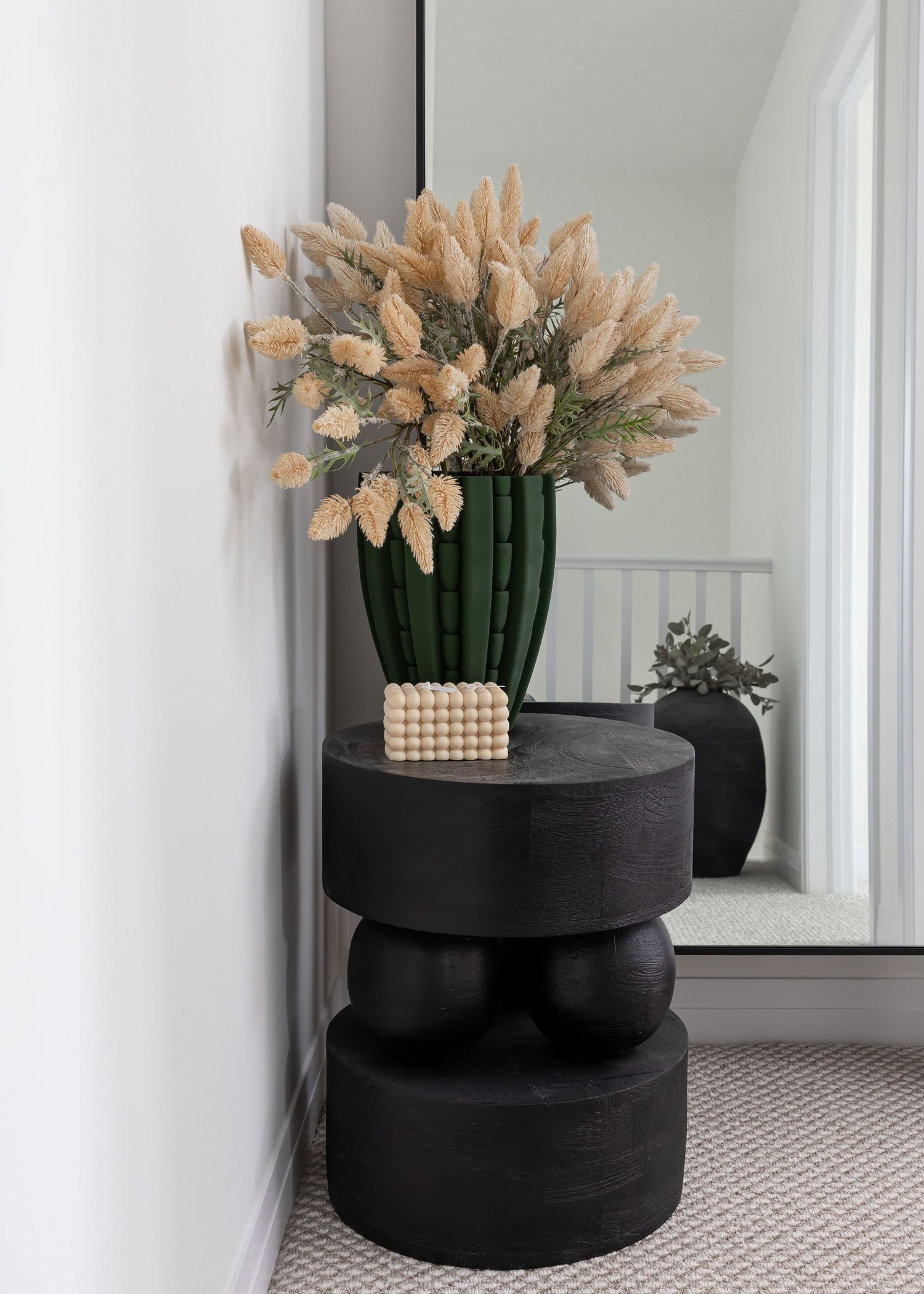 Black circular decorative containers with peach-colored floral arrangements on carpet.