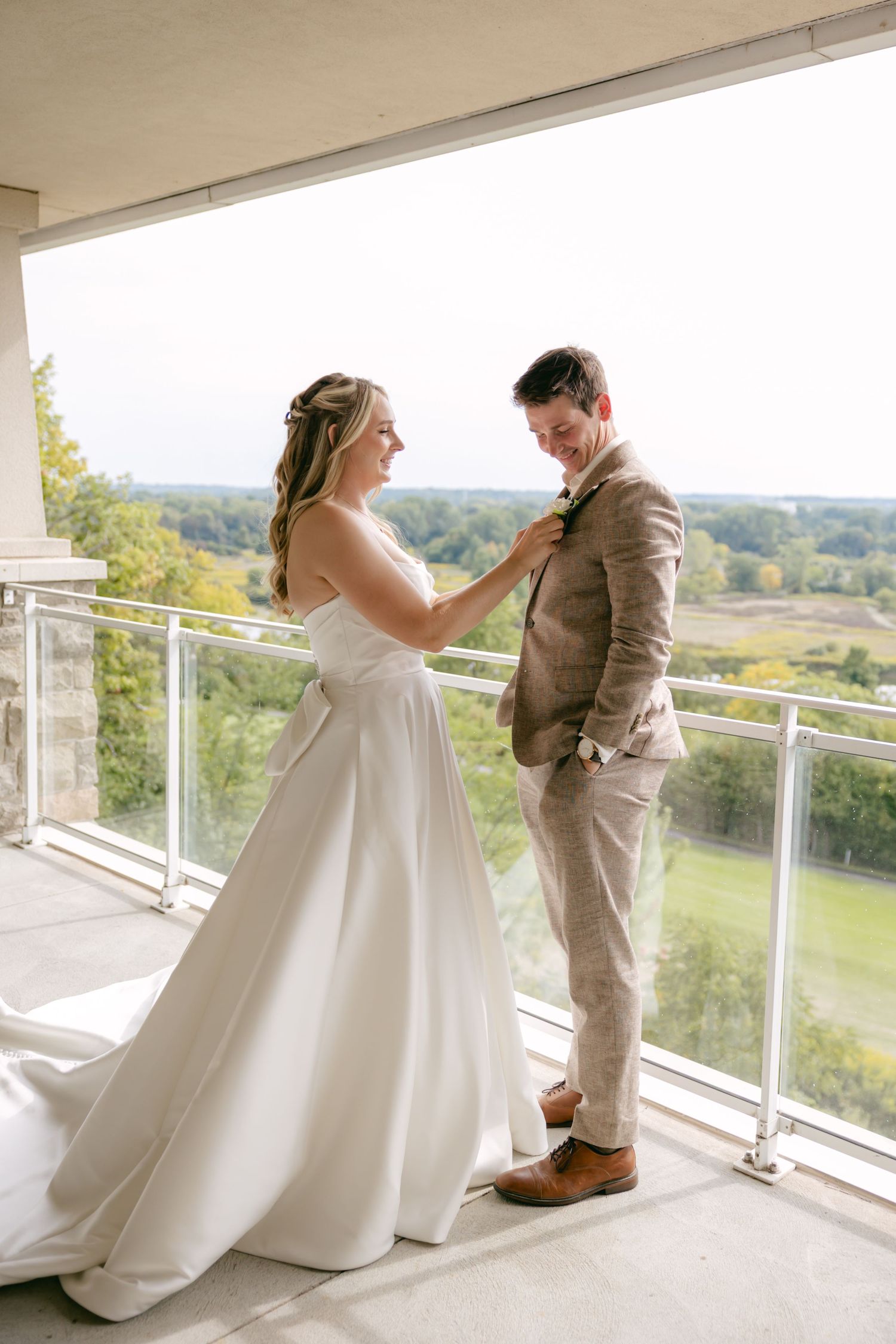 A couple shares an intimate moment on a balcony overlooking a scenic landscape.