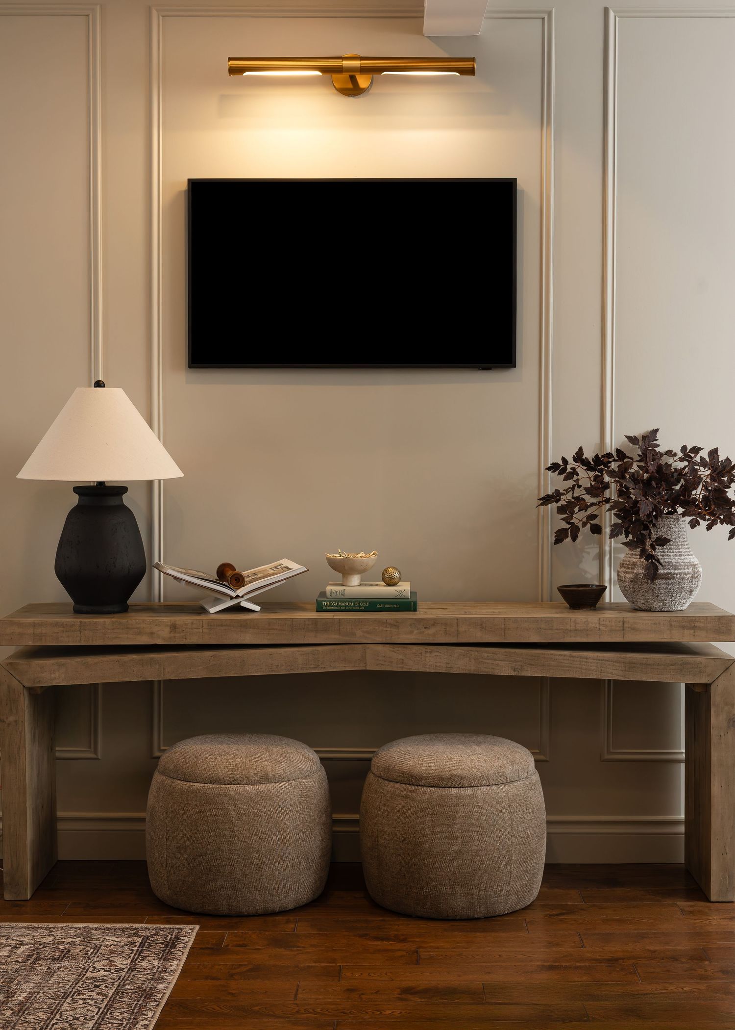 Modern living space with curved wooden bench and round upholstered poufs.