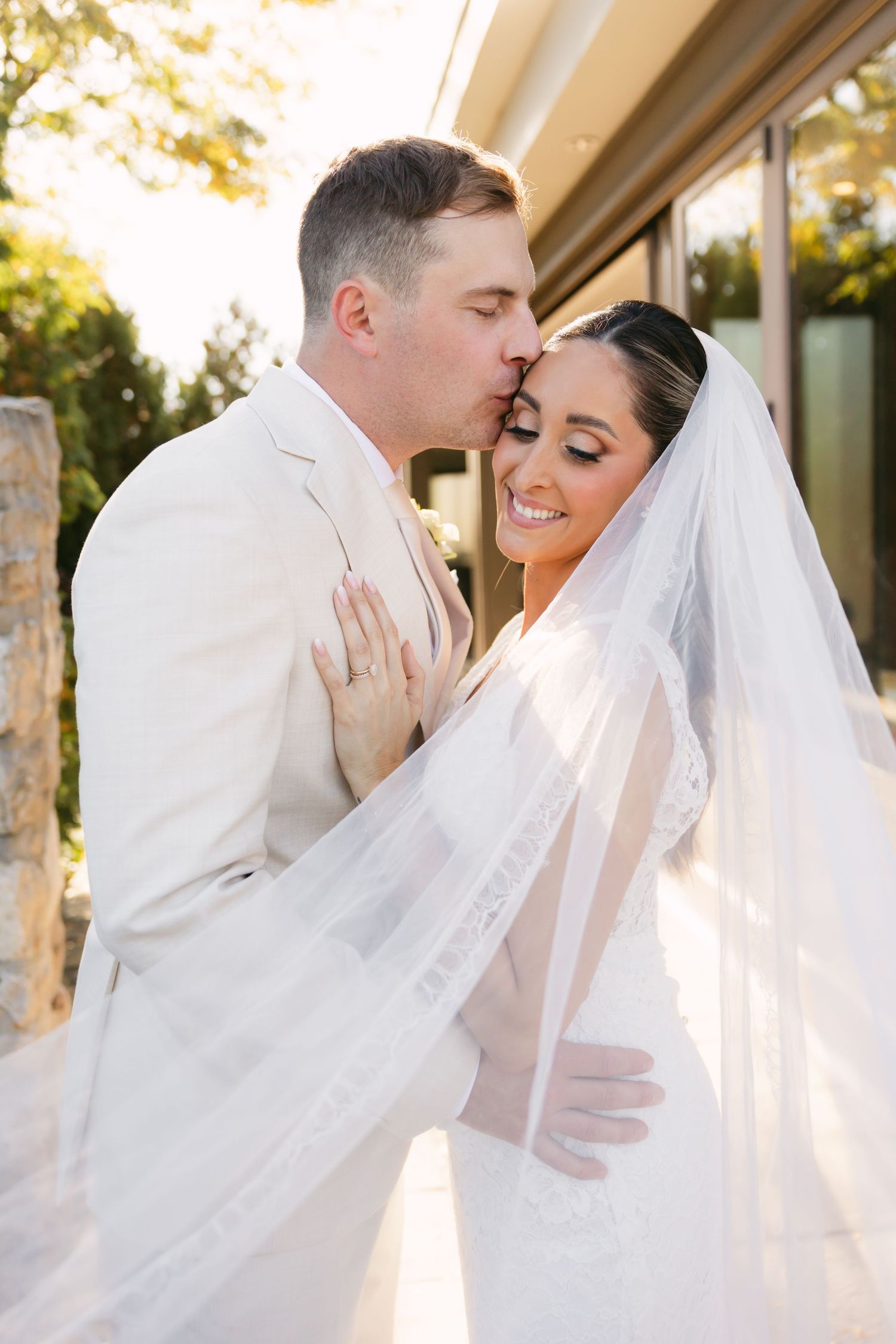 Sunlit wedding portraits showing romantic moments between newlyweds.