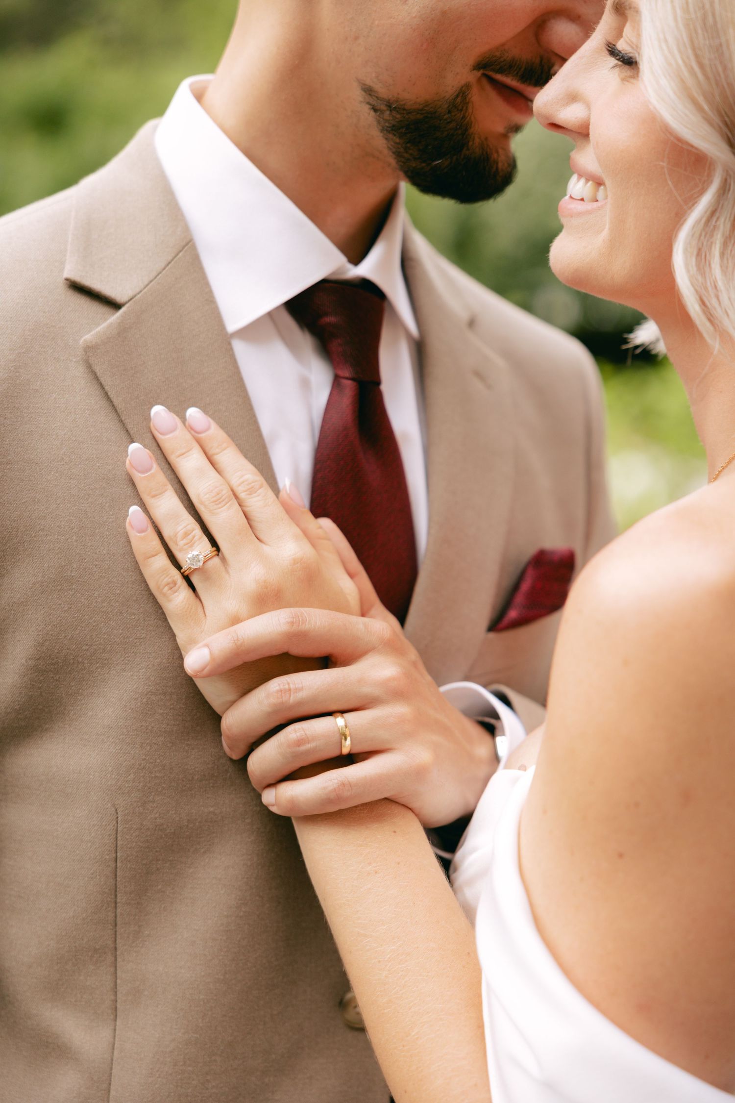 Close-up shot of tender wedding moments against a soft green background.