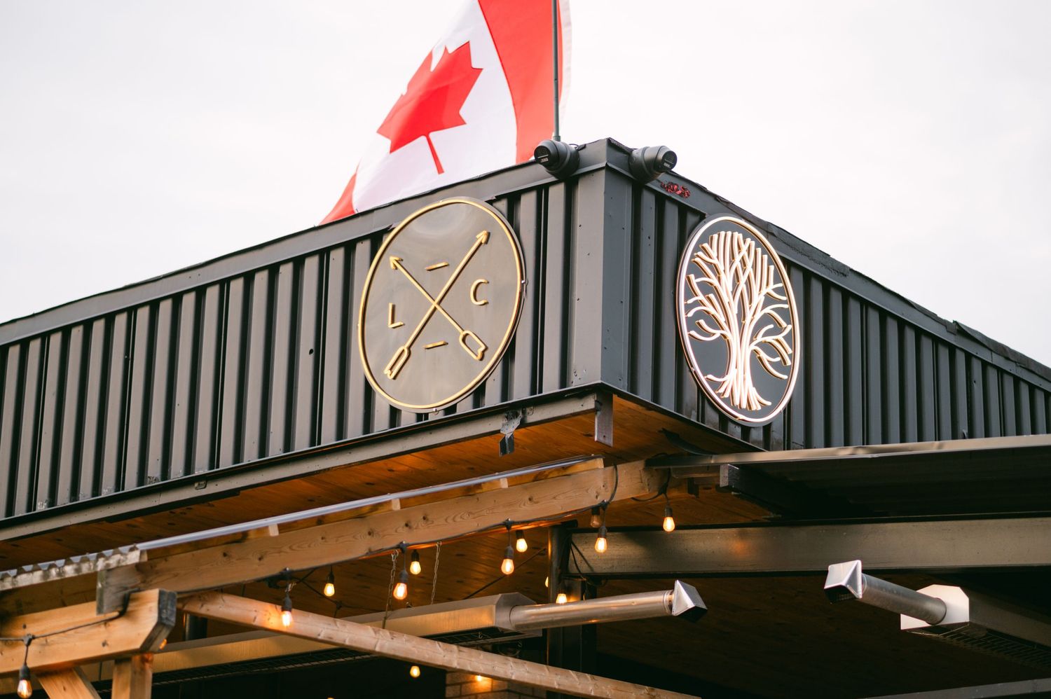 Industrial-style building exterior with decorative circular designs mounted on dark metal siding.